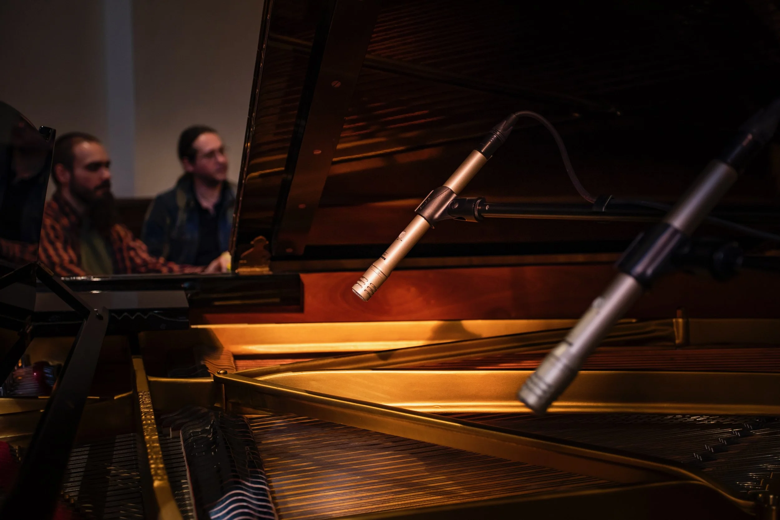 Deux micros placés au-dessus des cordes d'un piano à queue pendant une séance d'enregistrement