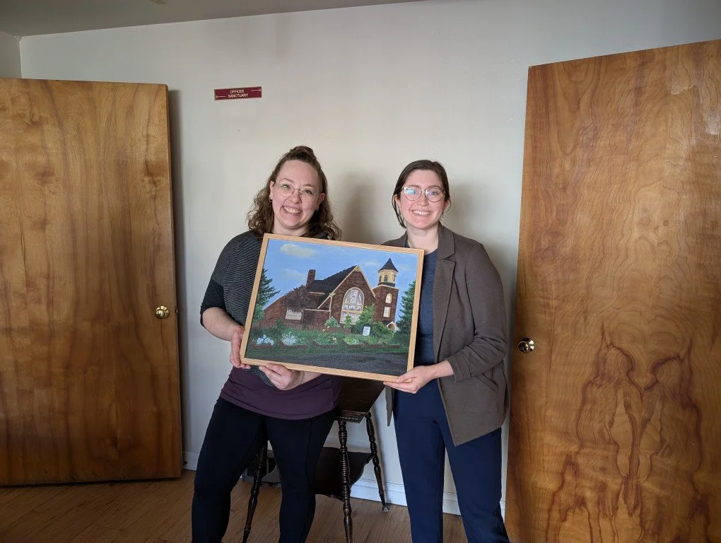 Heather, the artist on the left, holding an impressionist style acrylic painting with a representative of Wallingford Pedestrian Church.