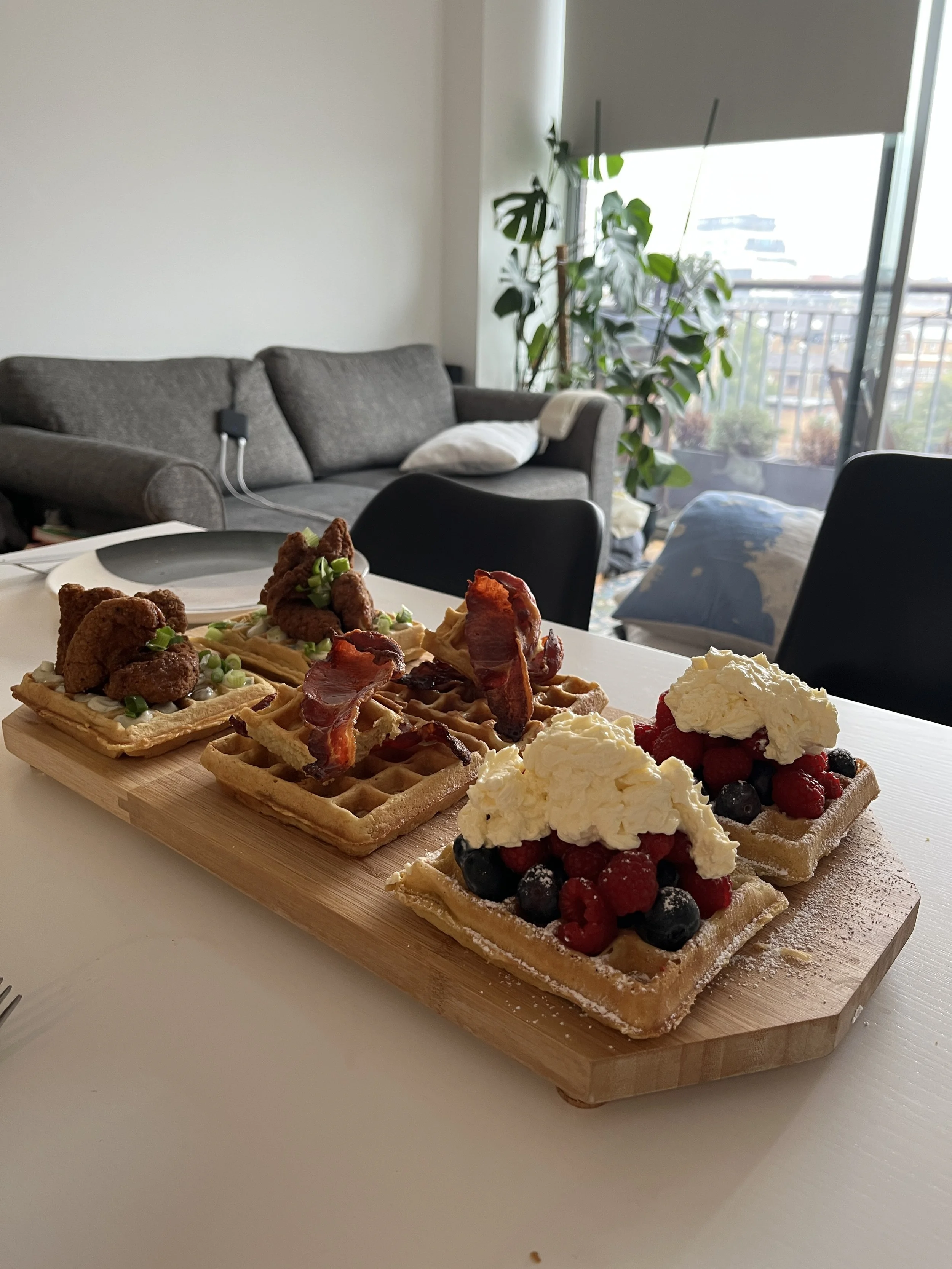 Waffles with fruit and cream on kitchen worktop