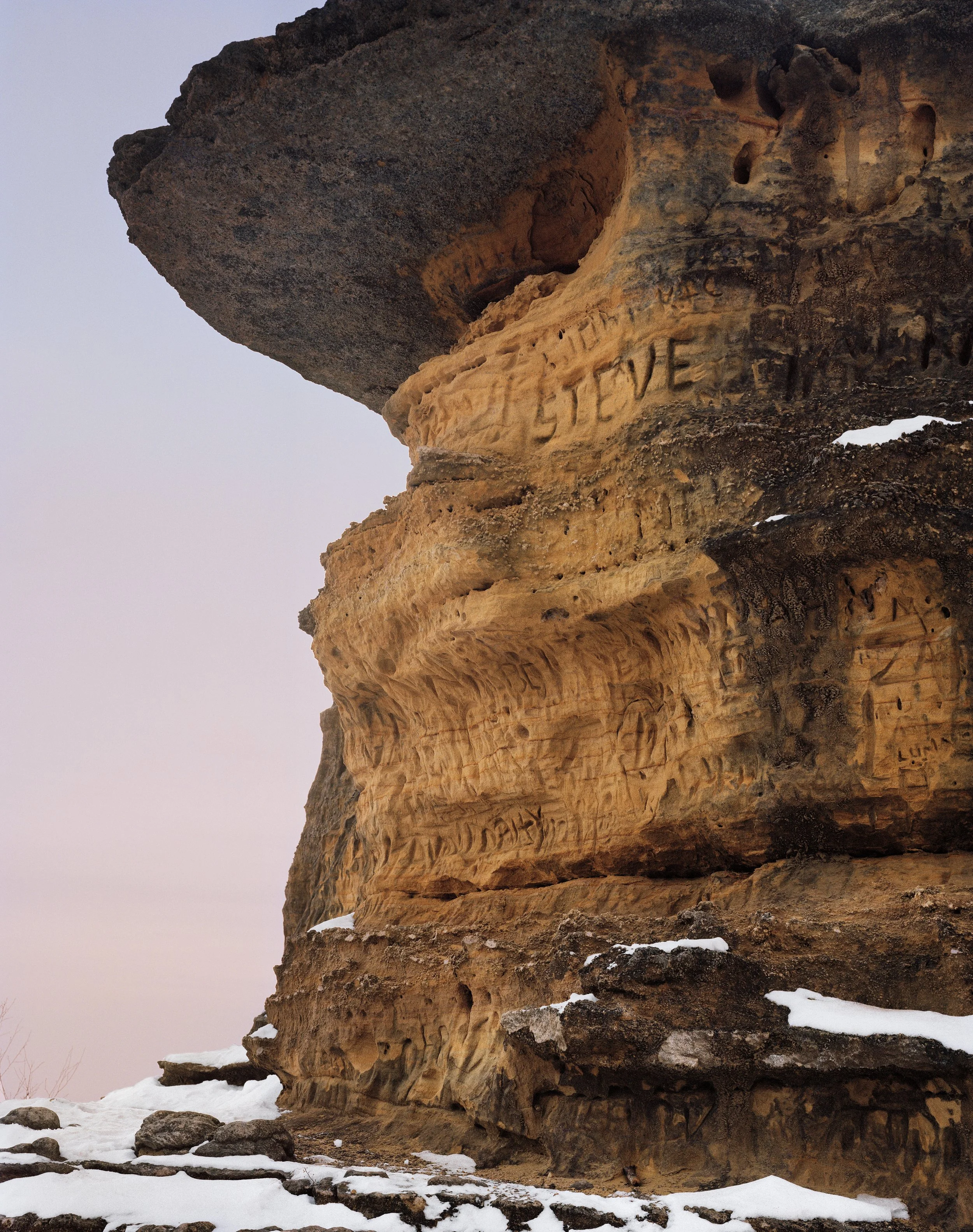 Roca natural de gran tamaño con un precipicio y un cartel de "Steve"
