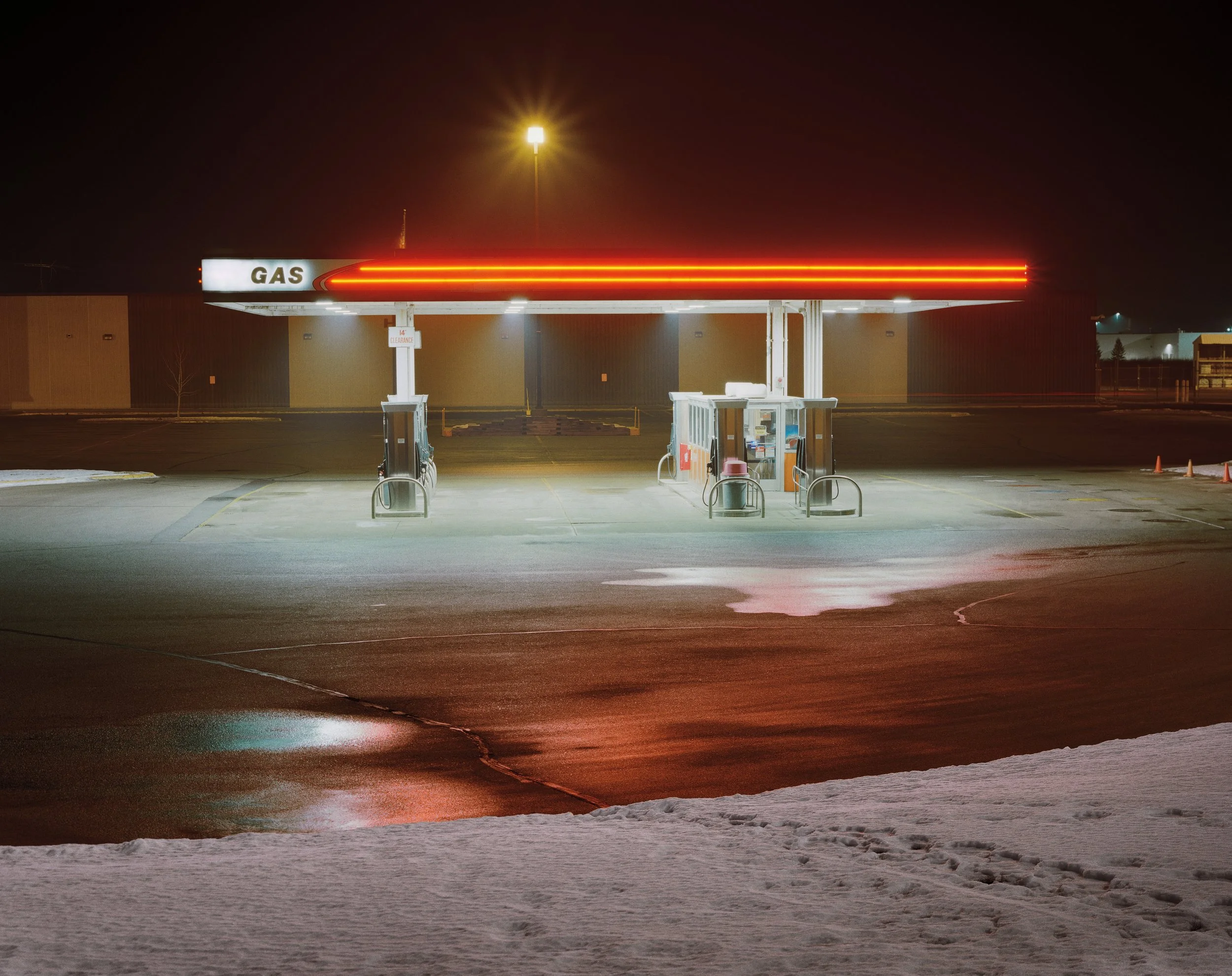 Estación de servicio vacía con iluminación roja brillante a la noche