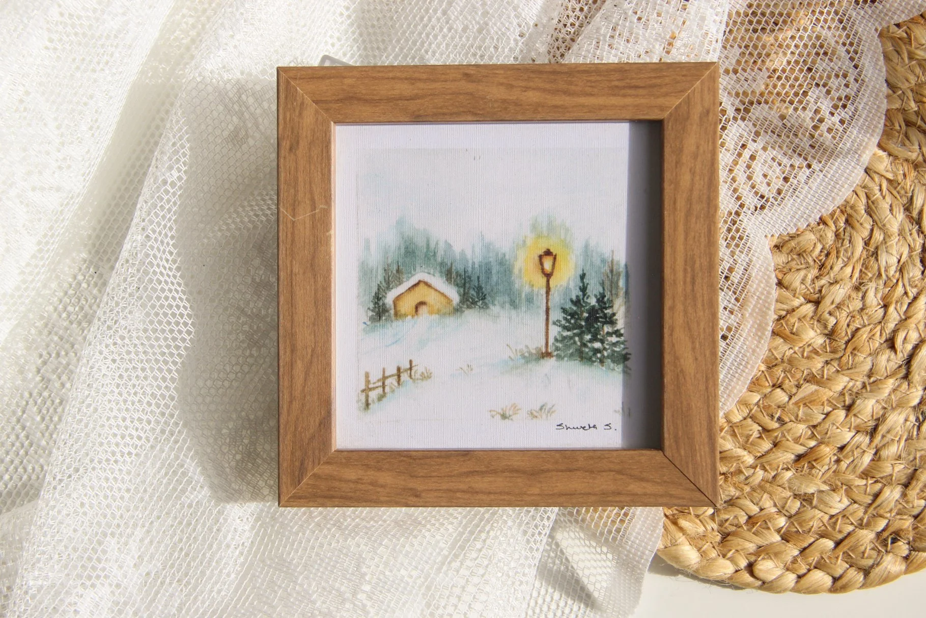 Light-up winter art print showing a snow-covered cottage under a glowing street lamp.