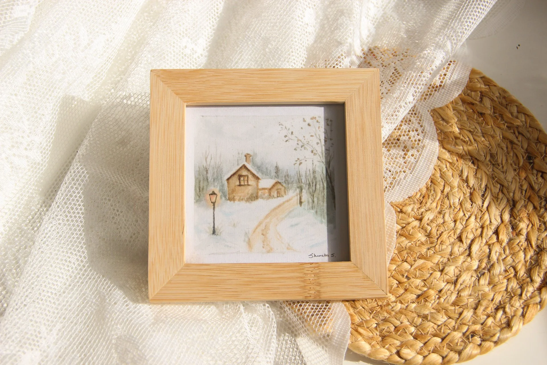 Light-up winter art print showing a snow-covered cottage under a glowing street lamp.