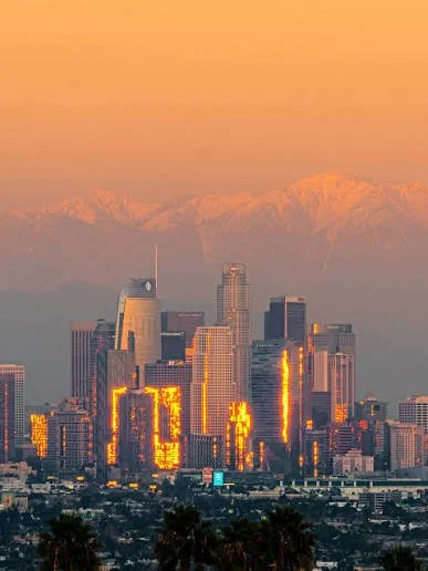 Skyline of downtown Los Angeles at sunset with the mountains in the background.