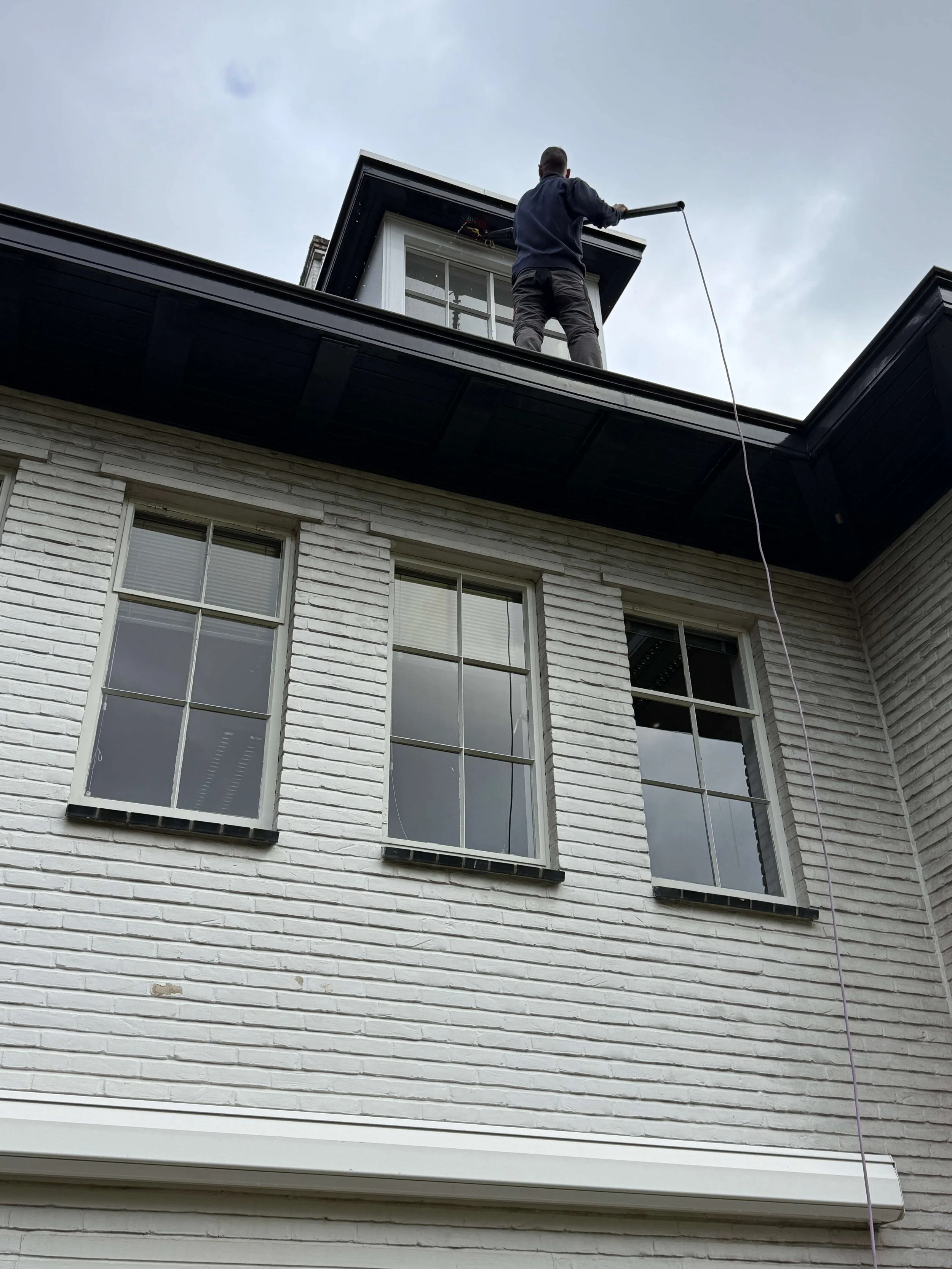 Reinigingswerkzaamheden aan de buitenzijde van een woning.