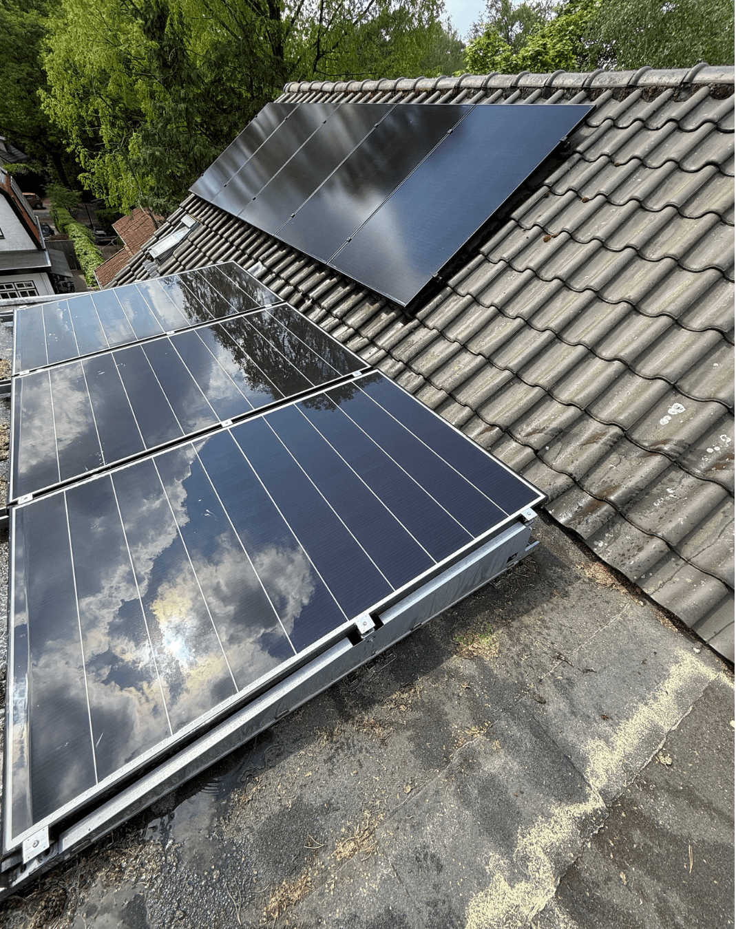 Zonnepanelen op een schuin pannendak van een woning.