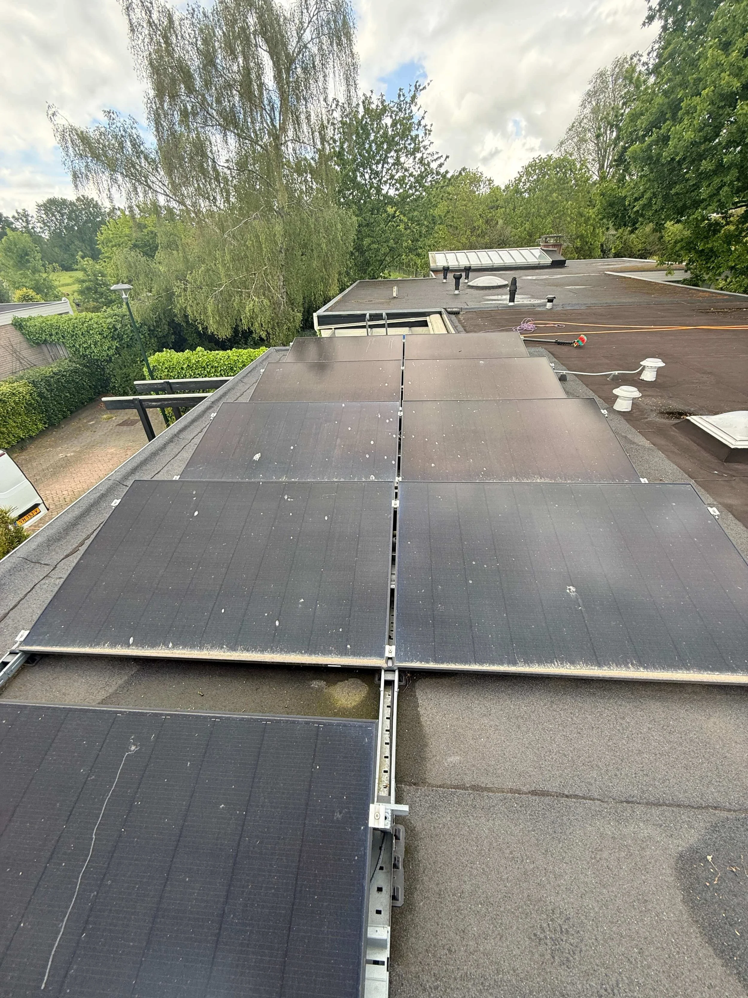 Rijen zonnepanelen op het platte dak van een gebouw.