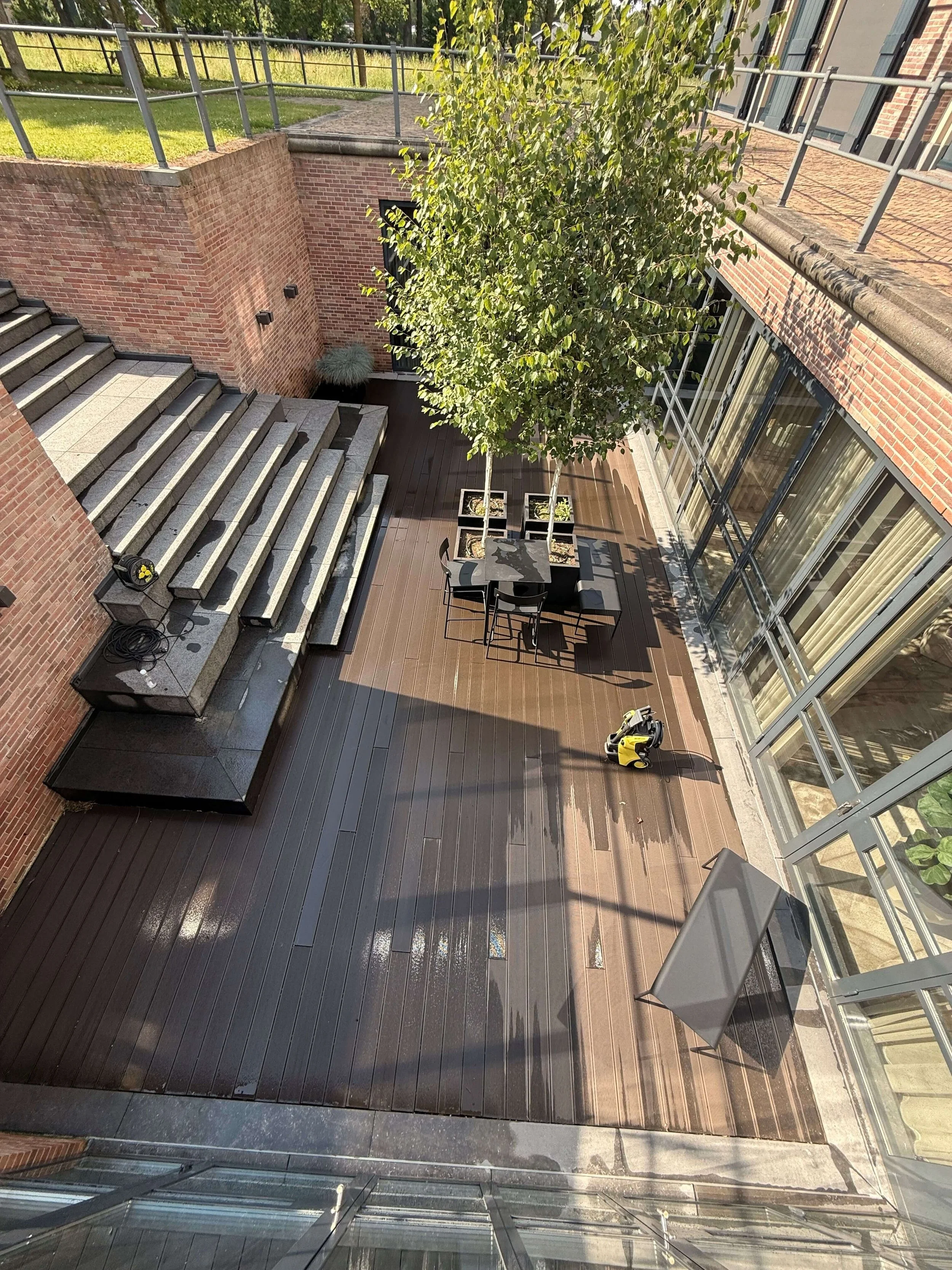 Terras met bestrating, trappen en buitenruimte bij een gebouw.