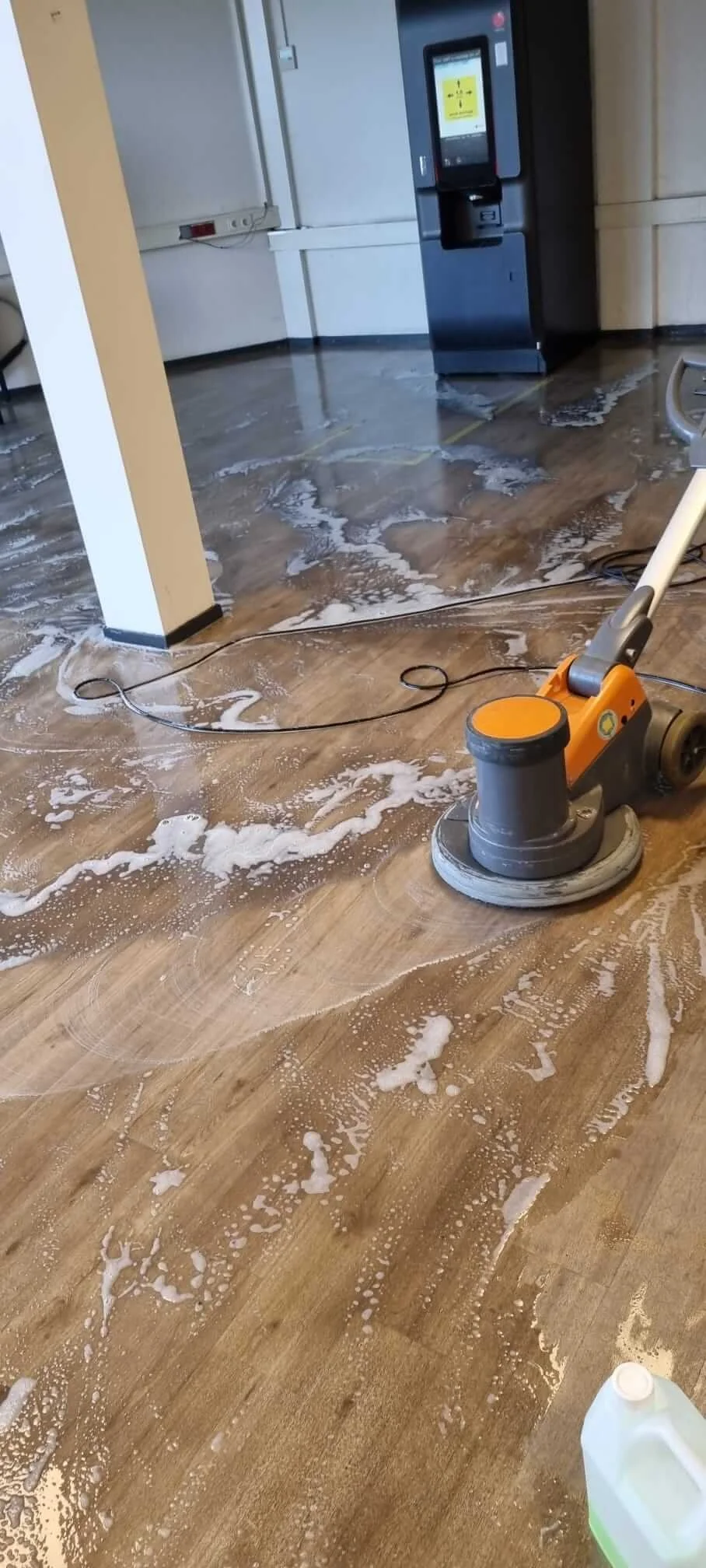 Professionele schrobmachine reinigt een vloer tijdens de opleveringsschoonmaak.