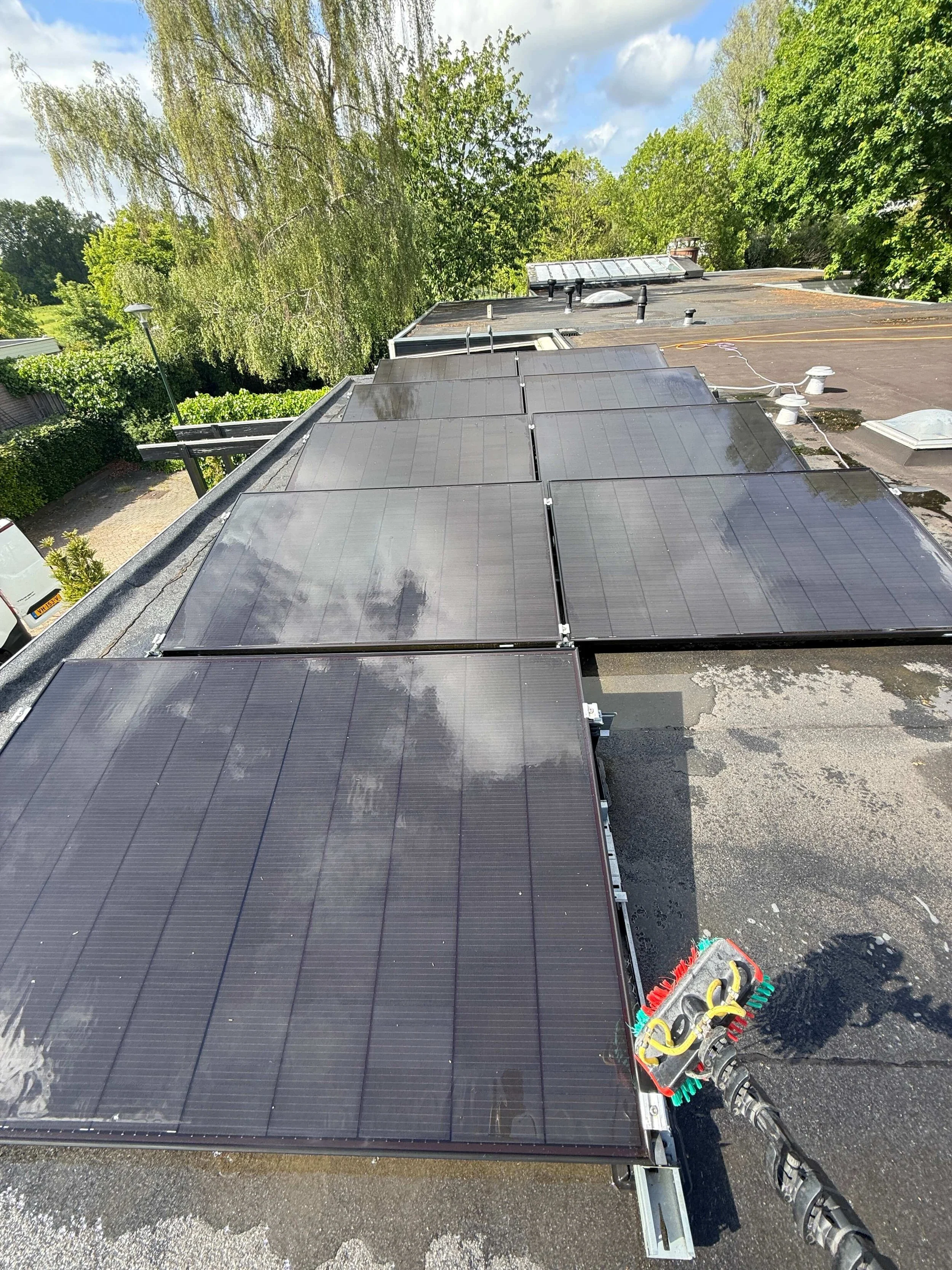 Reinigingsborstel op zonnepanelen tijdens professionele reiniging.