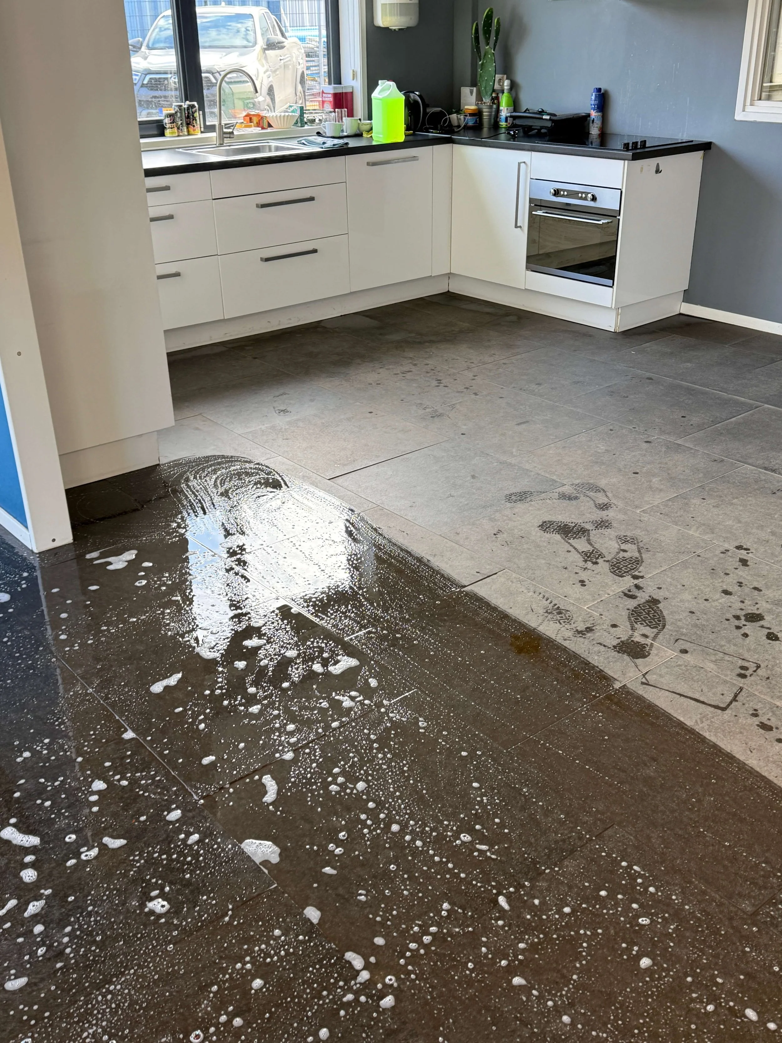Keukenvloer met reinigingsmiddel tijdens een grondige schoonmaakbeurt.