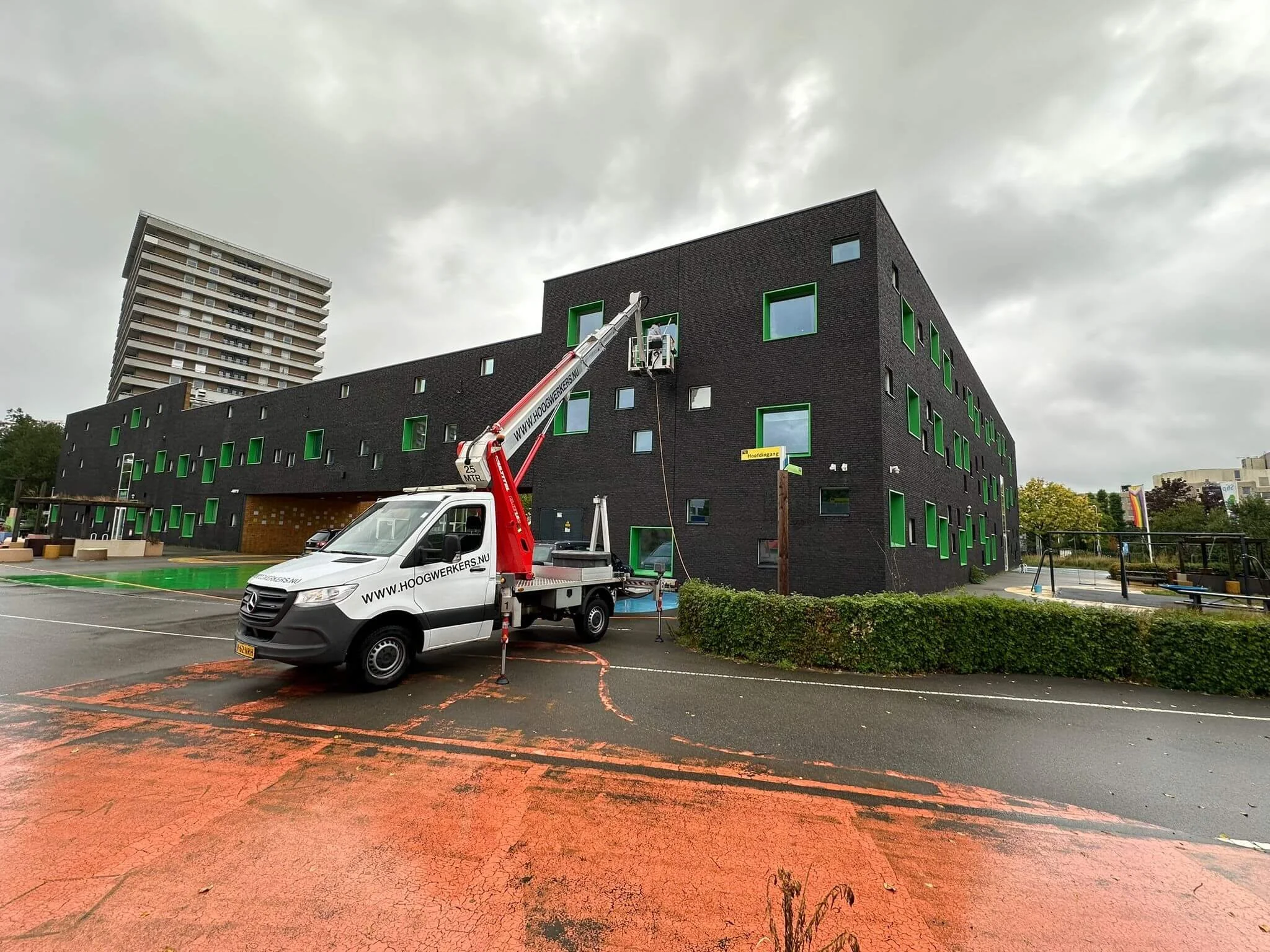 Glasbewassing van een bedrijfspand met een hoogwerker.