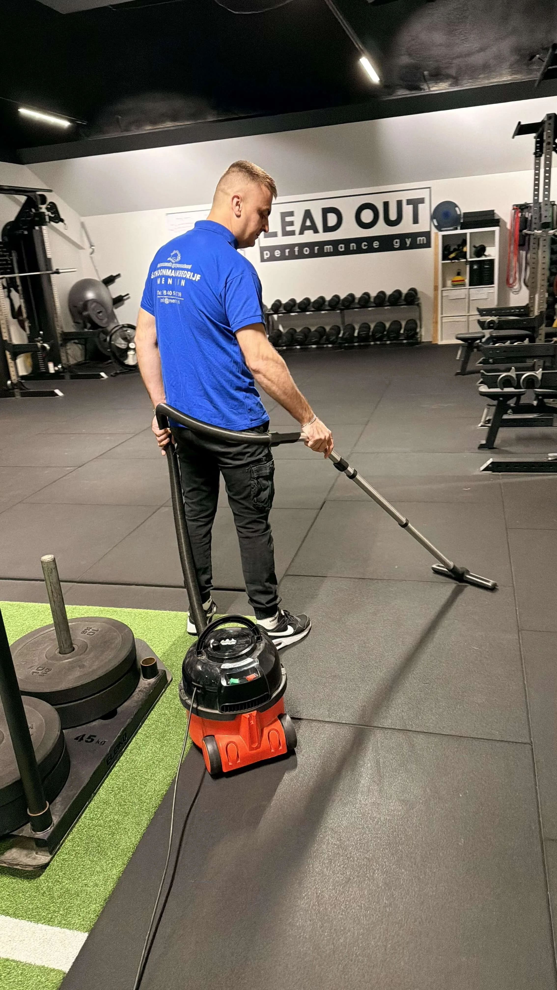 Schoonmaakmedewerker van Mentin reinigt de vloer in een fitnessruimte.