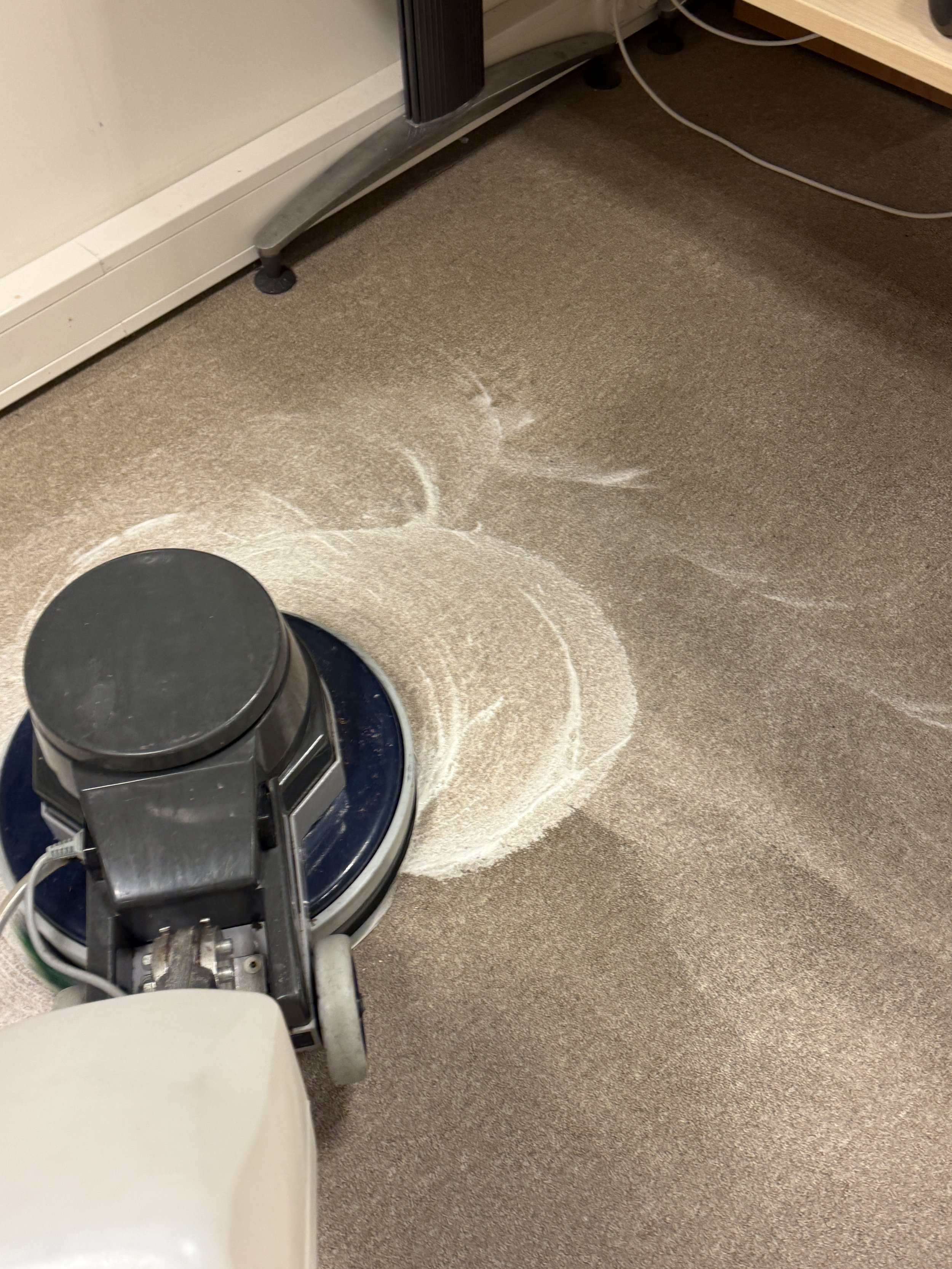 Professionele reinigingsmachine voor dieptereiniging van tapijt in een bedrijfsruimte.