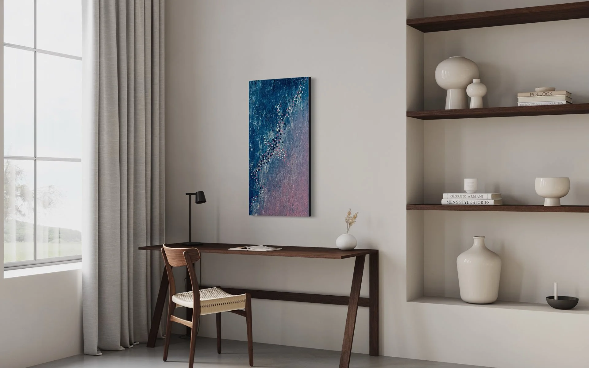 Modern interior with a large window and beige curtains, a wall-mounted abstract painting with blue and pink hues, a wooden desk with a black desk lamp, a woven chair, a white vase with dried flowers, and built-in wooden shelves with decorative white vases, books, and a black bowl.