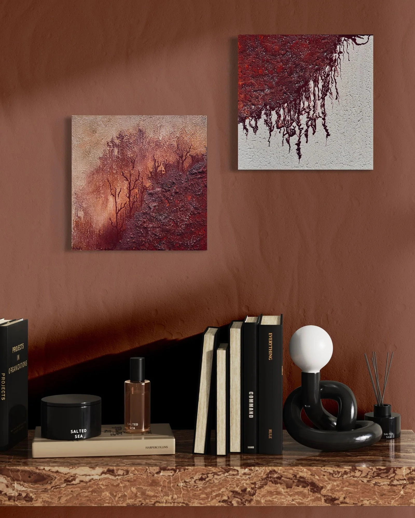 Close-up of a bookshelf with books and decorative items against a brown wall with two paintings featuring autumn trees.