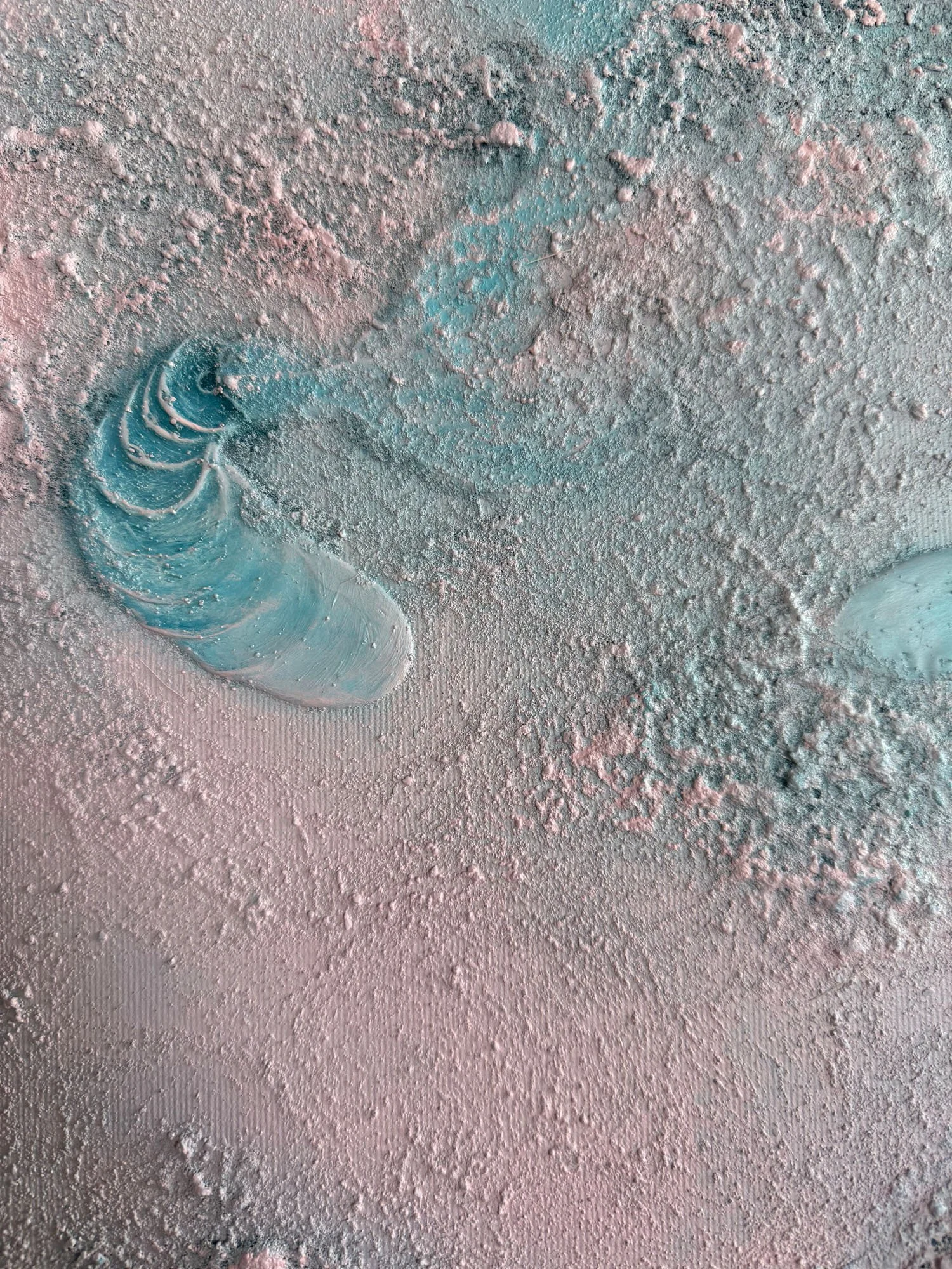 Close-up of a textured surface covered with powdery substance, with a spiral seashell partially embedded in the powder toward the lower left.