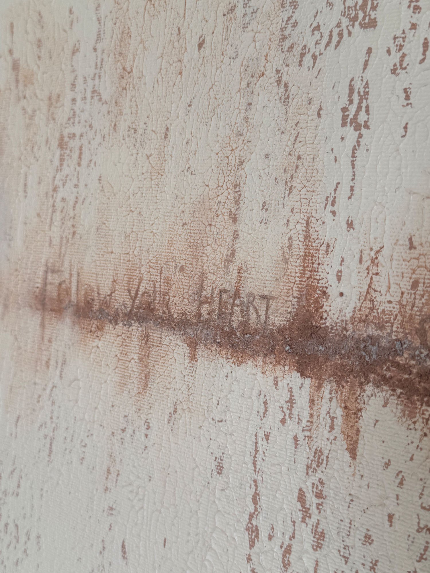 Close-up of a textured wall with peeling paint revealing layers of aged paint in shades of white and brown.