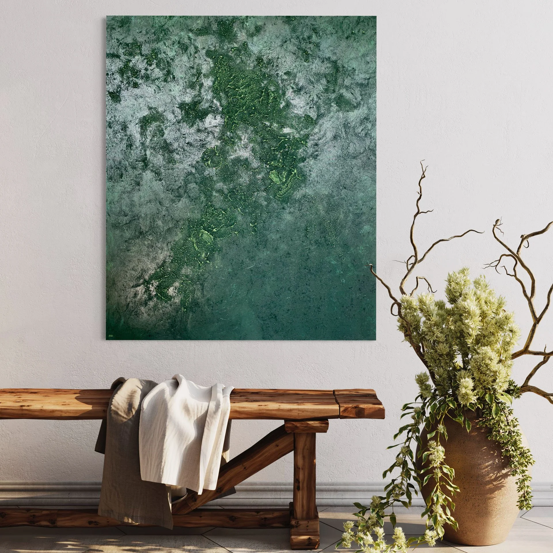 Decorative image with a textured green abstract painting hanging on a white wall, a wooden bench with a draped cloth, and a tall beige vase with green foliage and light-colored flowers.