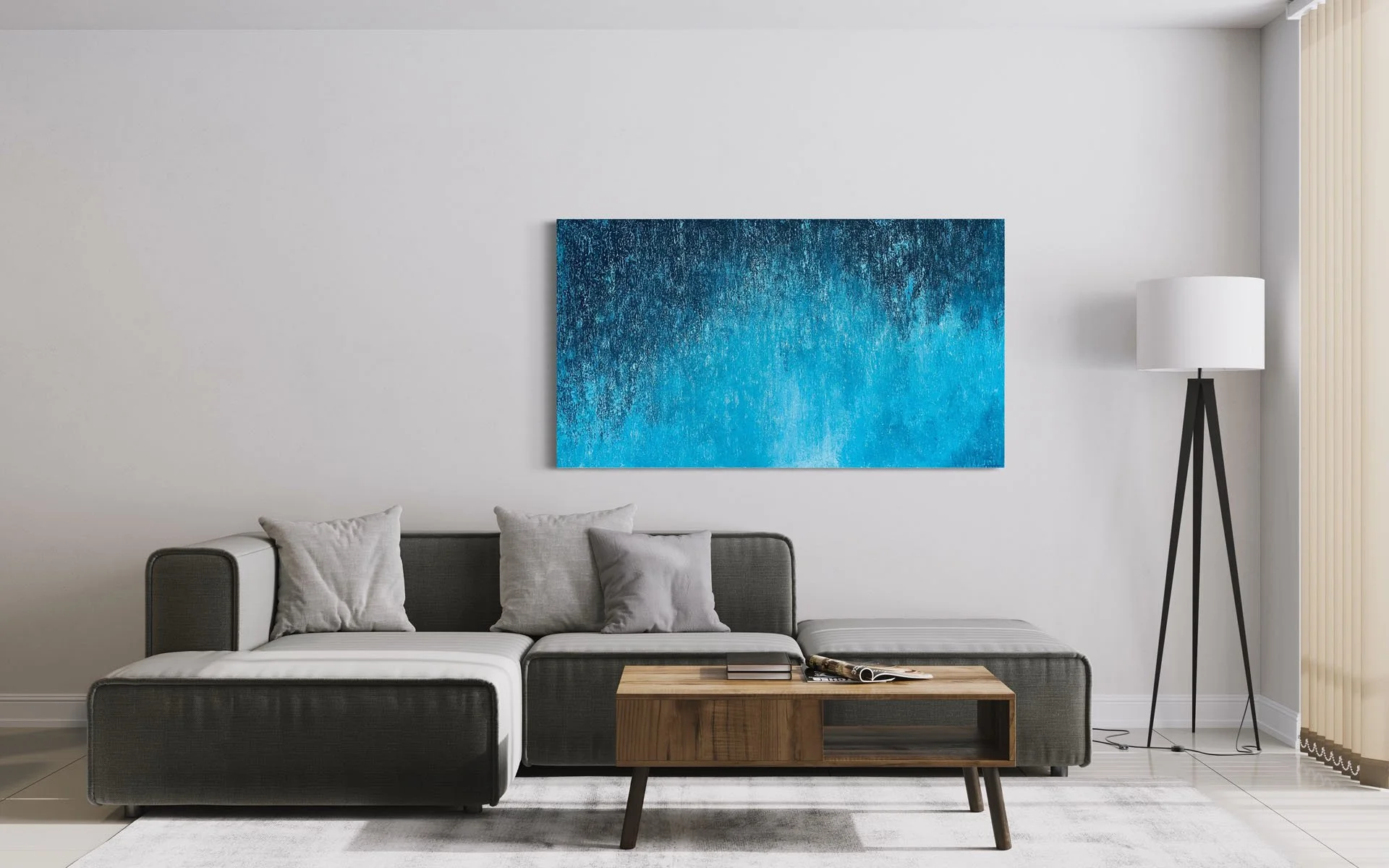 Modern living room with gray sofa, white walls, a blue abstract painting on the wall, a wooden coffee table with books, a black tripod floor lamp, and vertical blinds on the right side.