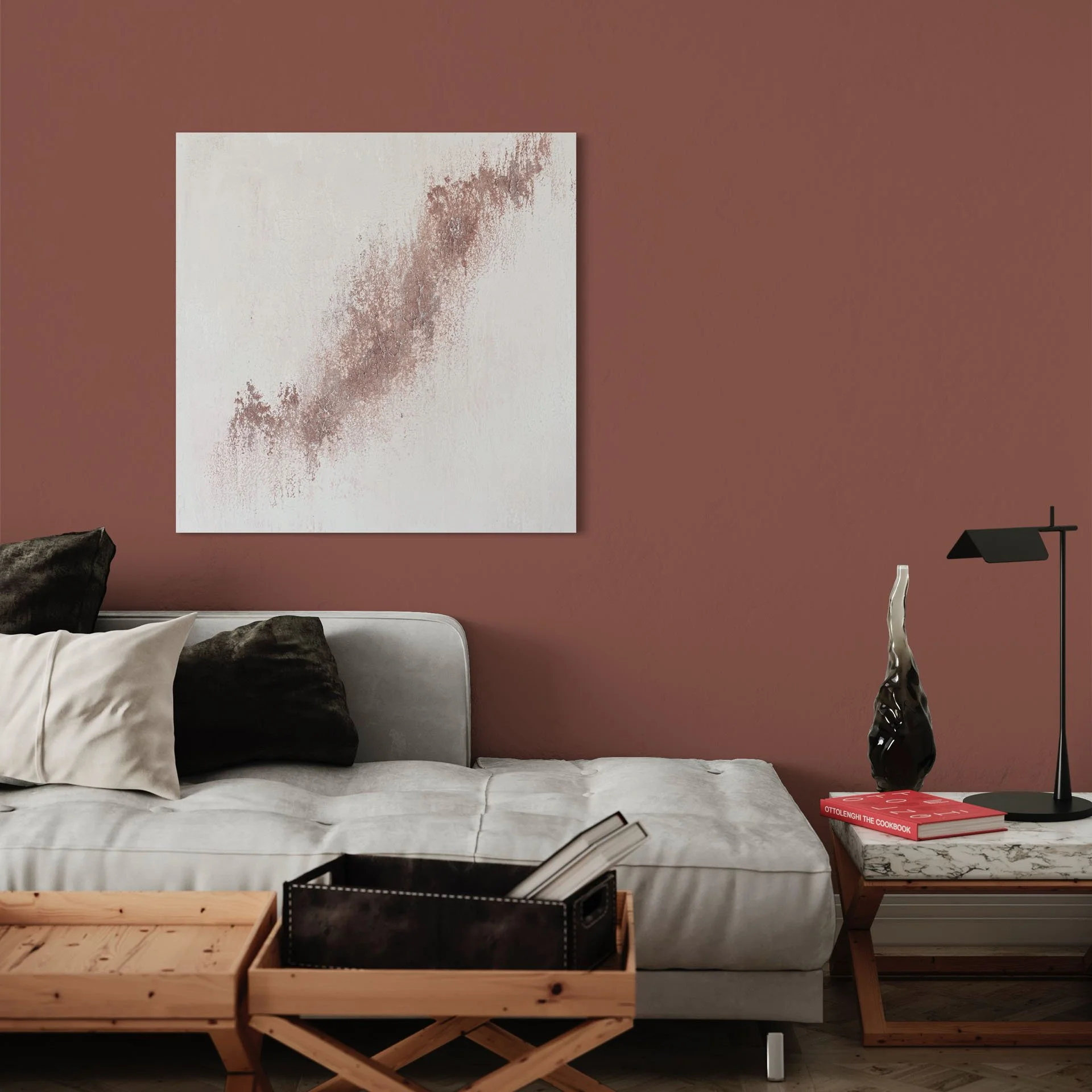 A living room with a white sofa adorned with black and white pillows, a wooden coffee table, and a marble side table displaying a decorative sculpture and books. A large abstract artwork hangs on a reddish-brown wall, with a black floor lamp nearby.