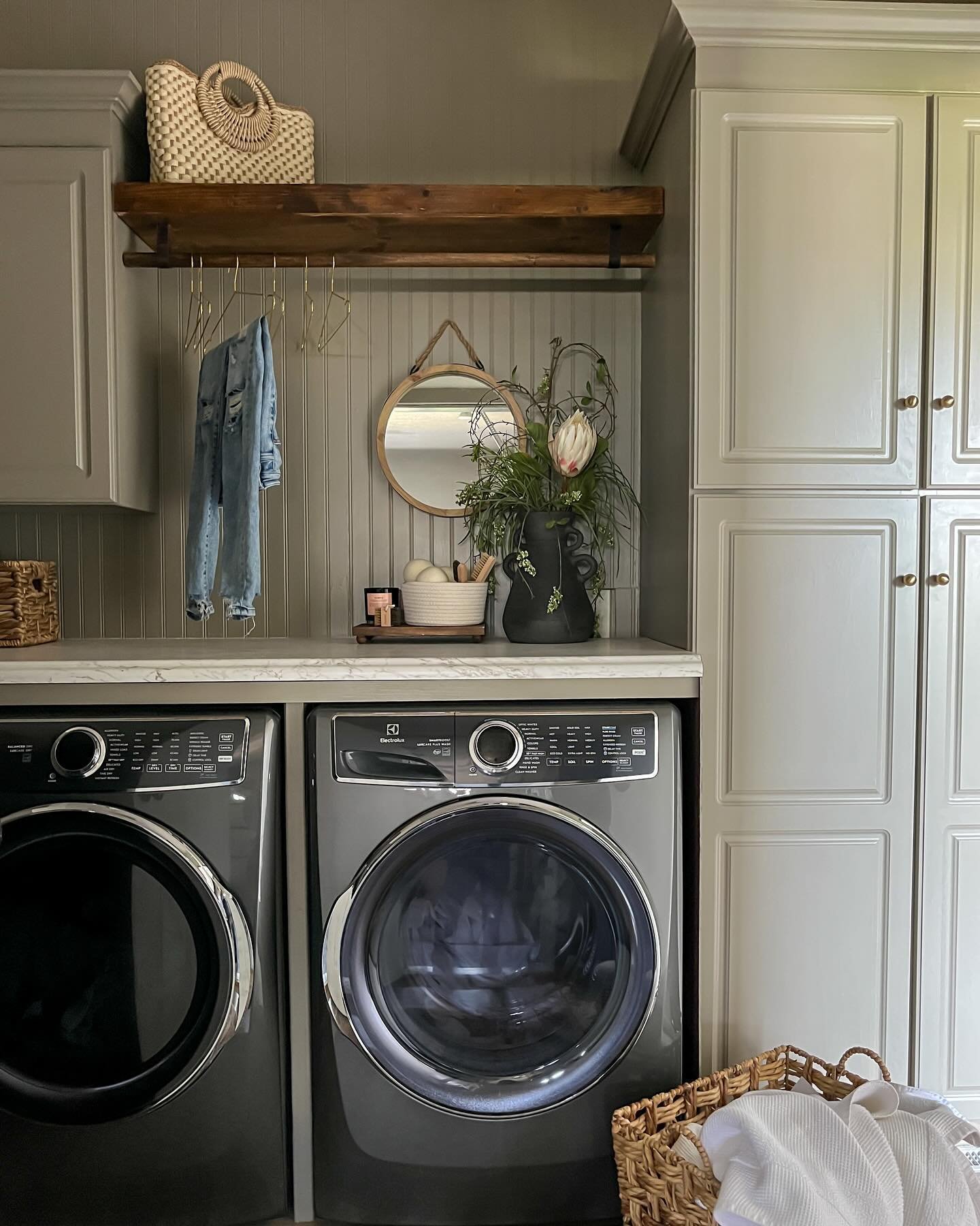 See what magic a little paint can do?
This laundry room began as nothing remarkable, but through the simple acts of removing a few cabinets and introducing beadboard, a hanging rod, charming hardware, and wall-to-wall countertops, it&rsquo;s a whole 