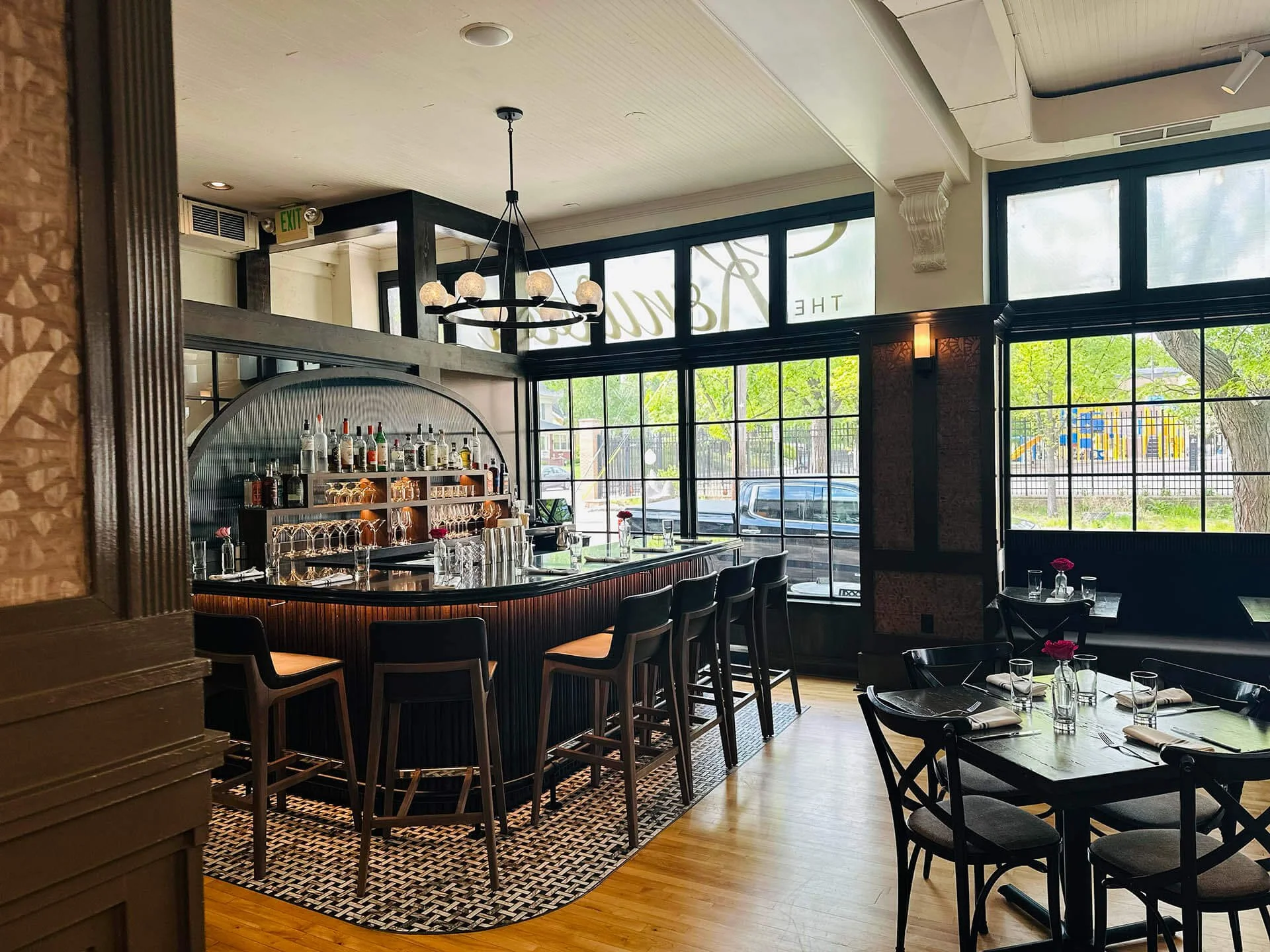 Beautiful interior of The Kenwood restaurant with paneled windows, wood accents, and a curved bar.