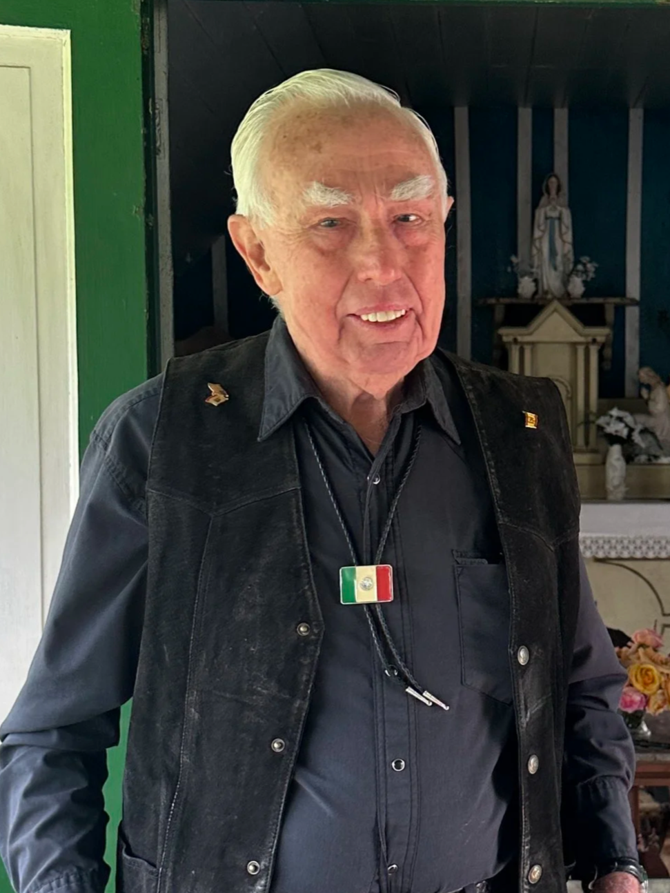 One of our decents, Gordon Uppman standing in the chapel doorway, wearing a black shirt, black vest, and a belt with a large silver buckle.