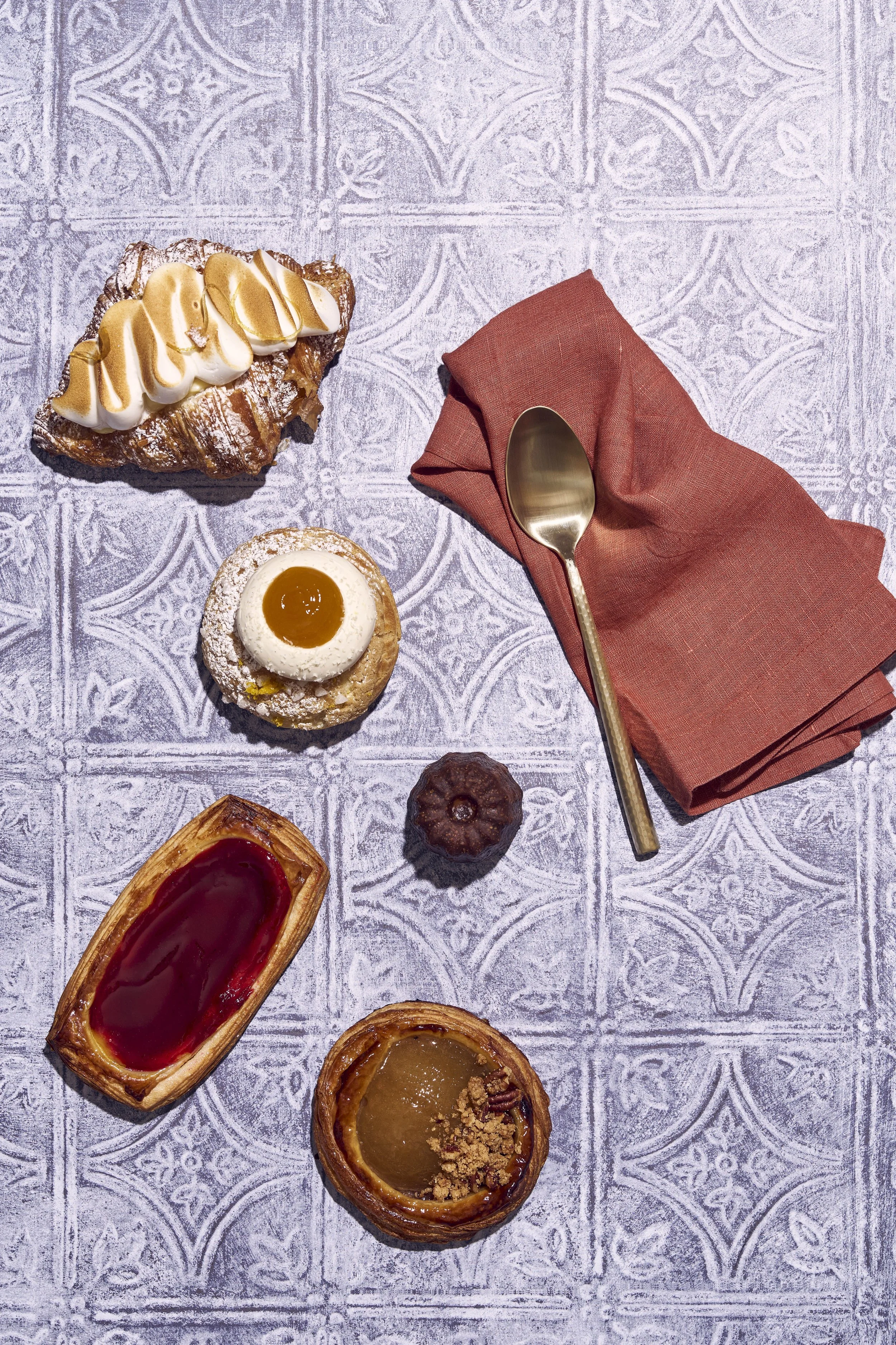 Food photographer in Denver, assorted pastries displayed on a textured table with a red napkin and a gold spoon.