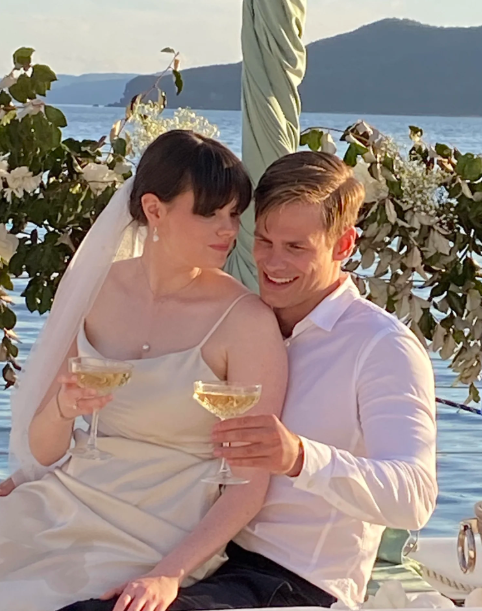 Wedding couple celebrating with drinks aboard a private yacht