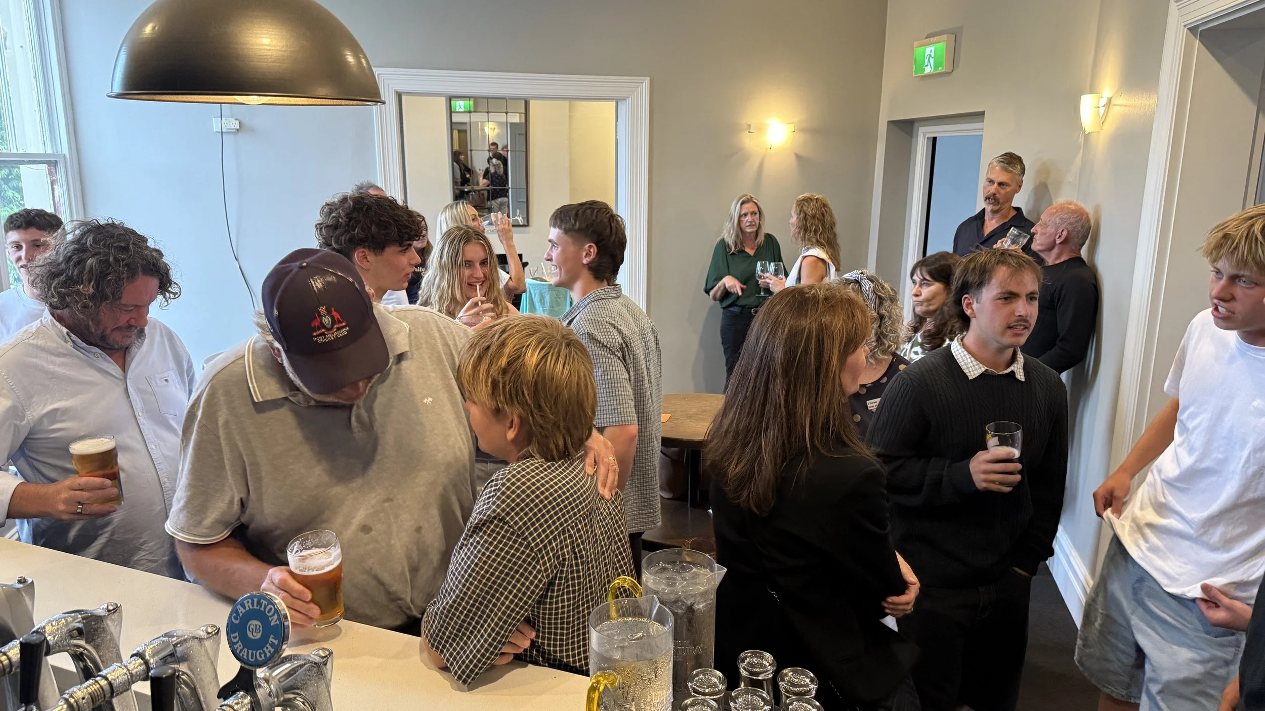 People socializing at a birthday party upstairs at the Palace Hotel with drinks and casual conversation