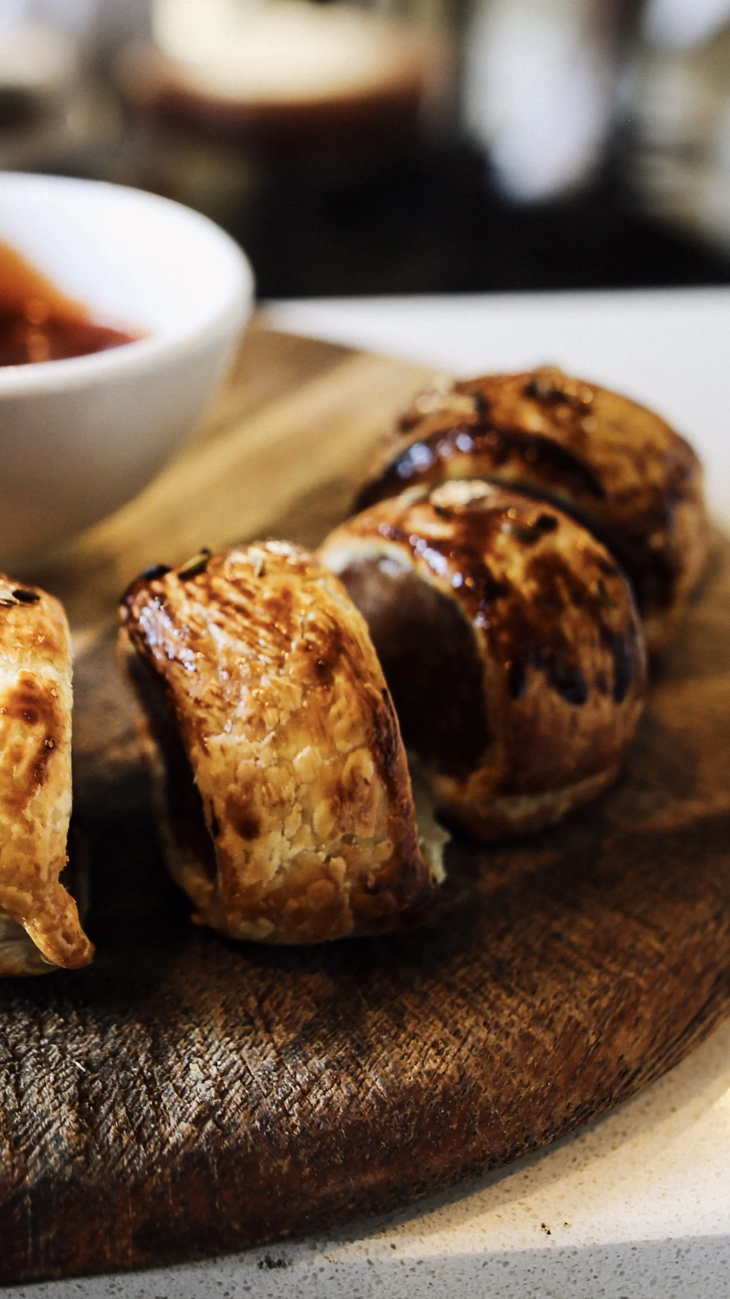 Close-up of grilled chicken skewers on a wooden board with a small bowl of dipping sauce in the background upstairs at the Palace Hotel.