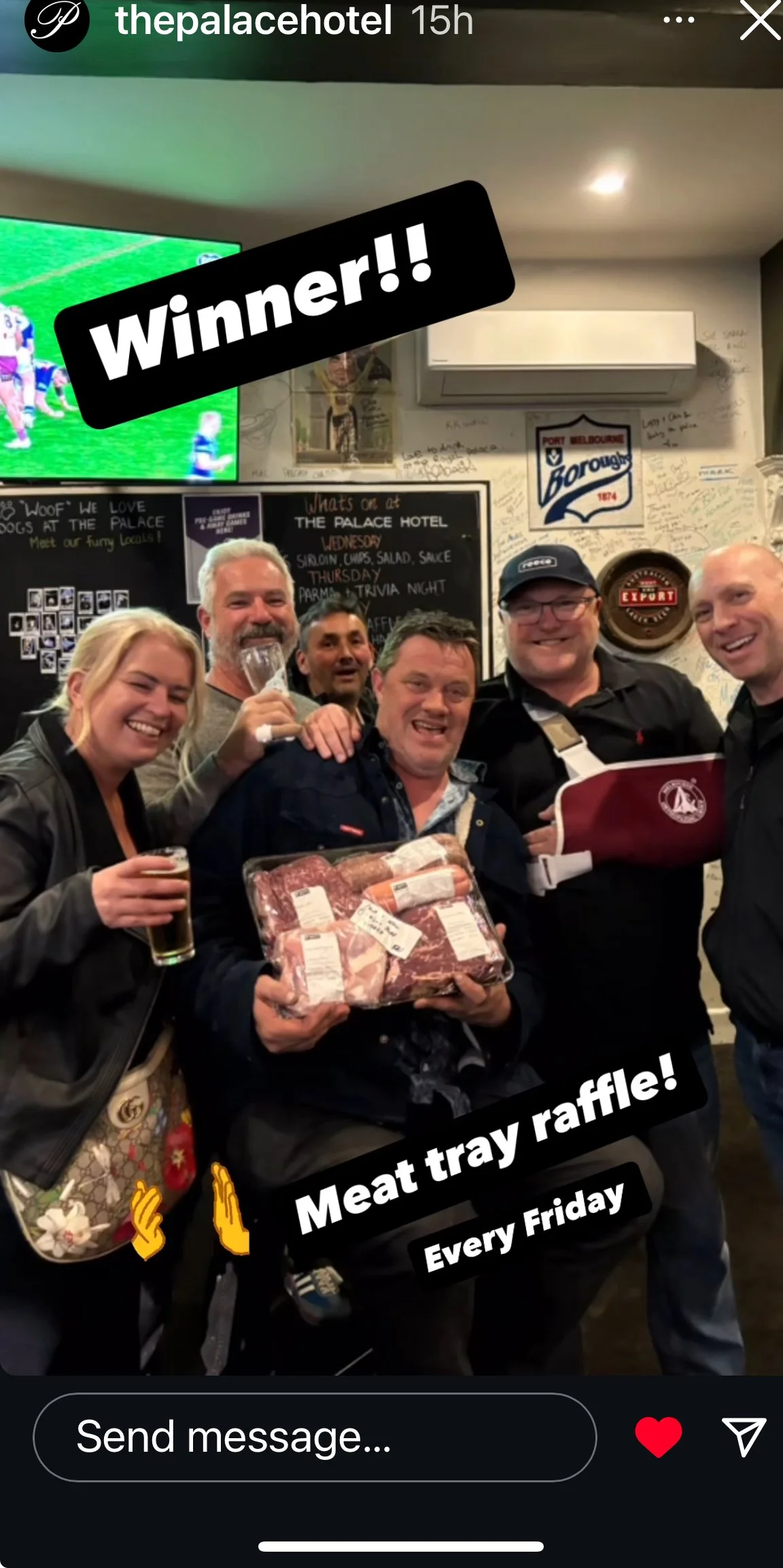 Group of five people celebrating a meat raffle victory at the Palace Hotel , with one person holding a tray of meat, others smiling and holding drinks, in a lively indoor setting with a chalkboard menu and sports TV in the background.