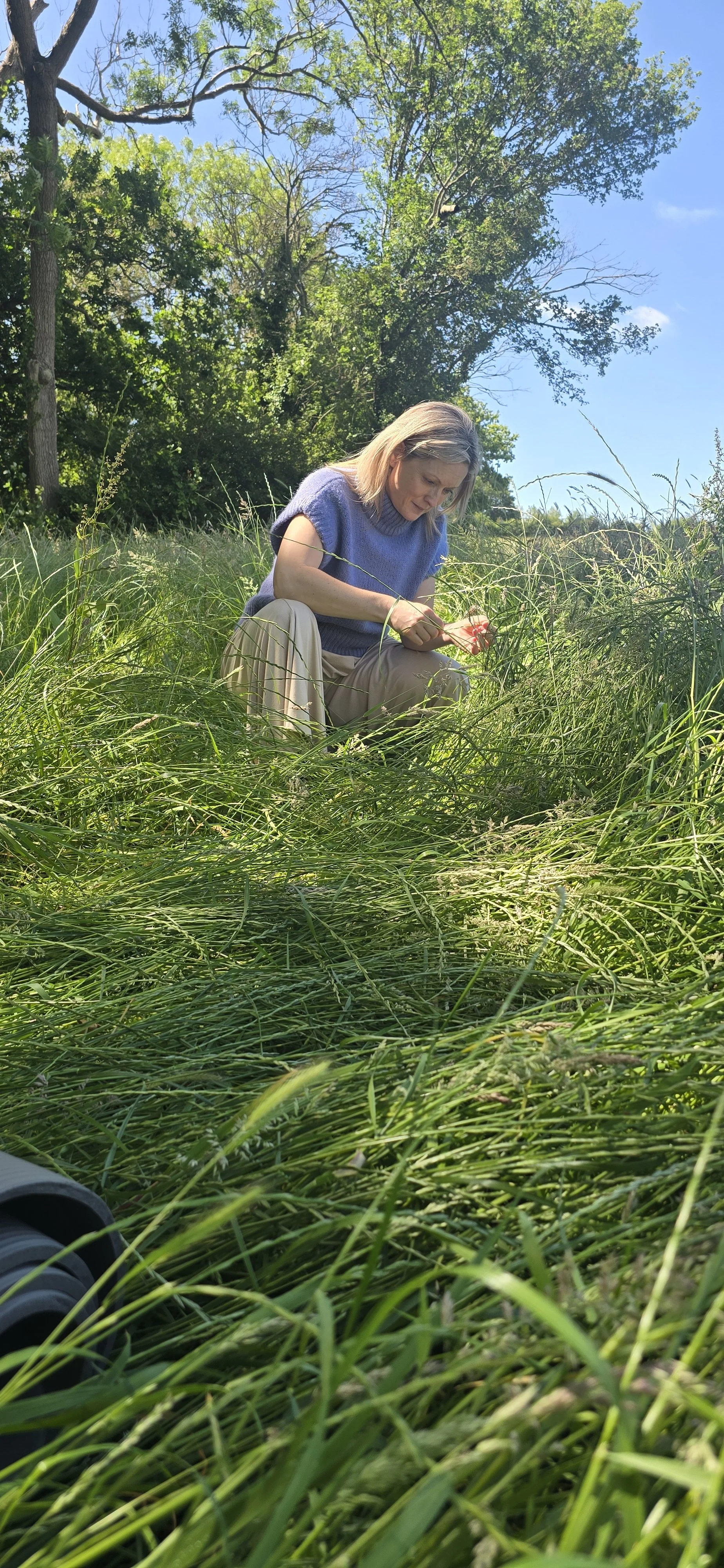 Host Emma in a meadow immersed in nature connection