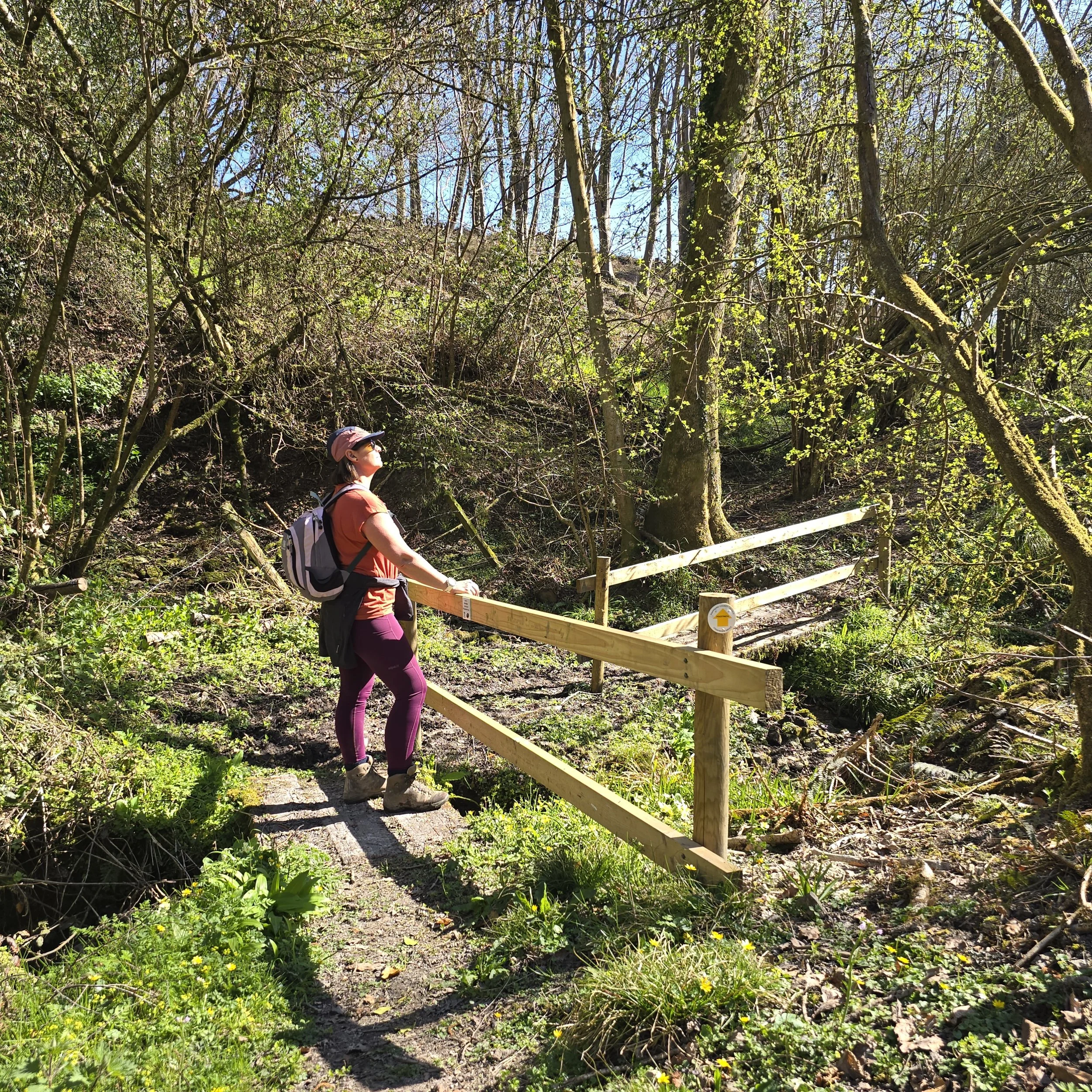 Chantelle in sunshine on a small bridge during a walk looking out at the views of the countryside