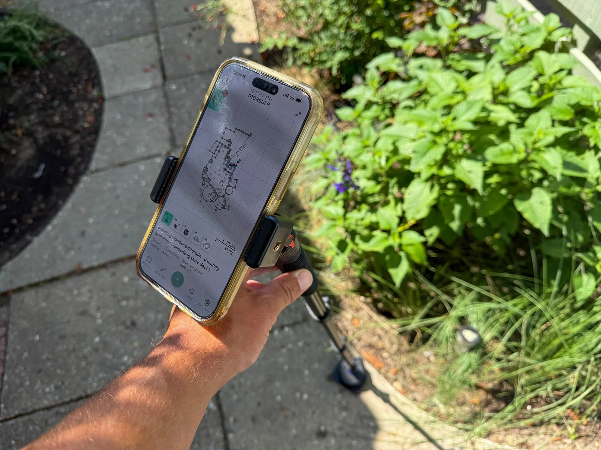 Digitale Moasure meetapparatuur gekoppeld aan een smartphone voor het digitaal inmeten van een tuin