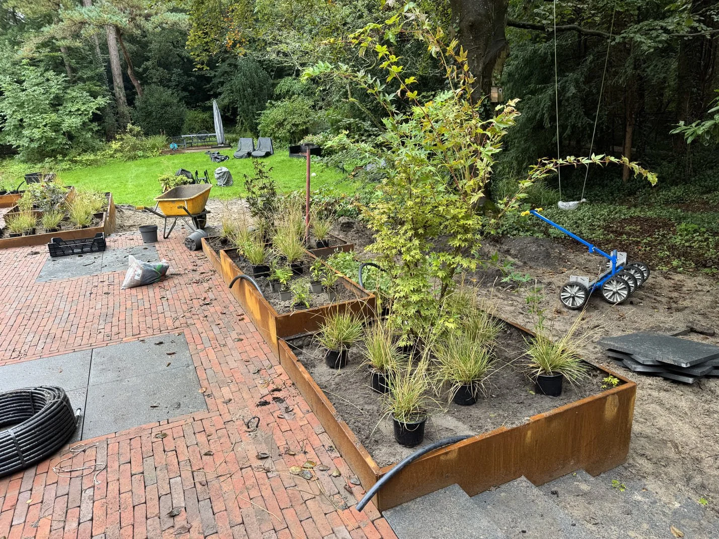 Projectbegeleiding tijdens tuinaanleg met beplanting en cortenstalen borders in uitvoering.
