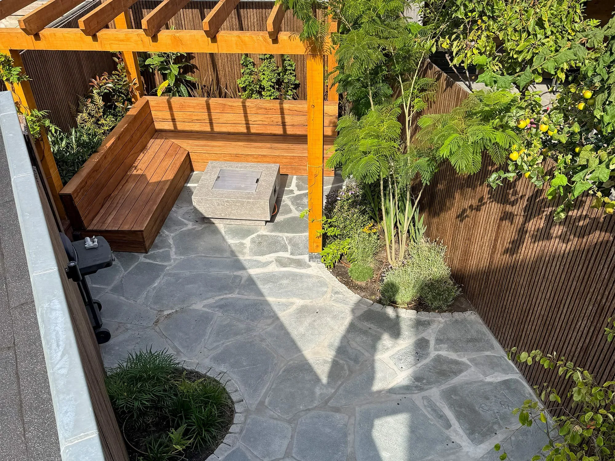 Vanuit vogelvluchtperspectief is de organische legrichting van de flagstones direct zichtbaar. De lichte voegen tussen de asymmetrische natuurstenen benadrukken het robuuste lijnenspel dat kenmerkend is voor mediterrane patio's en terrassen.