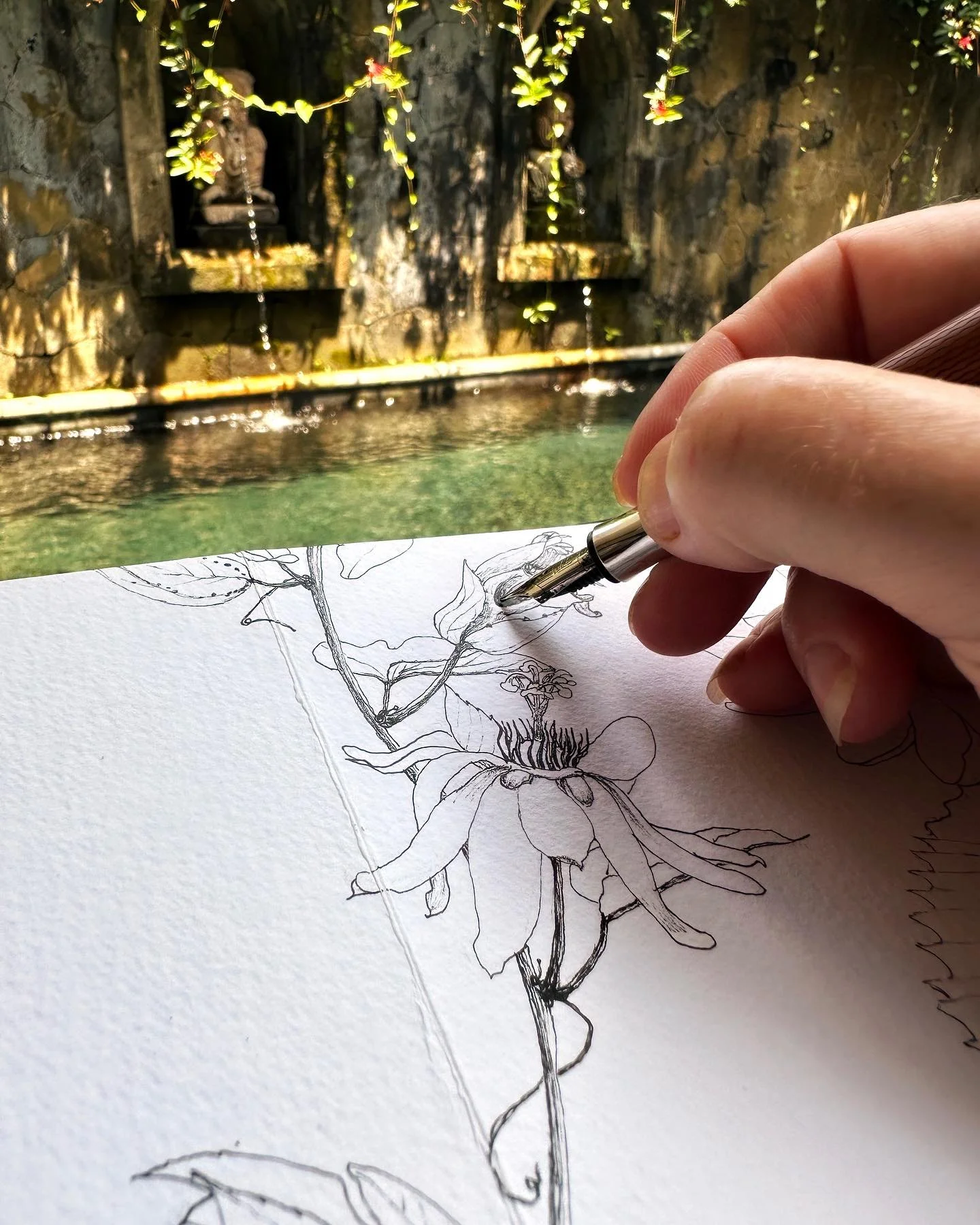 a hand sketching some flowers in Bali Ubud on location