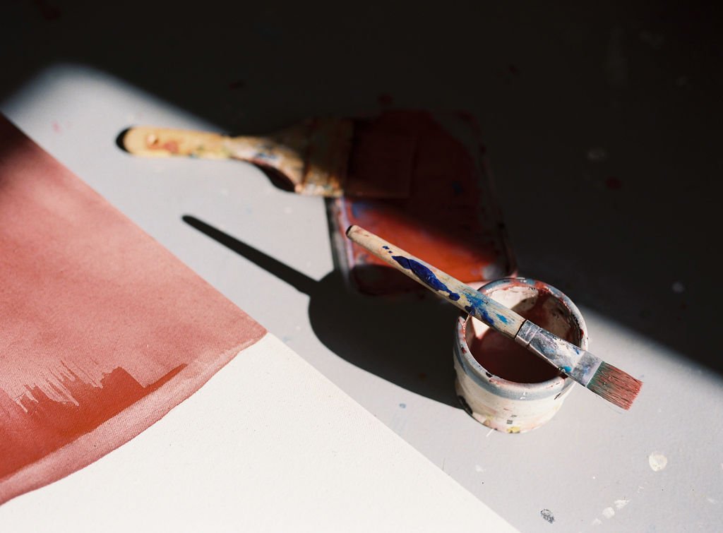 Paint, brushes and painting on the studio floor