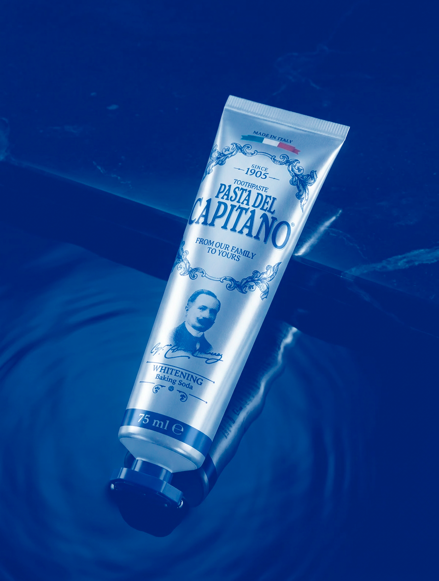 Tube of Pasta del Capitano whitening baking soda toothpaste floating on water with ripples.