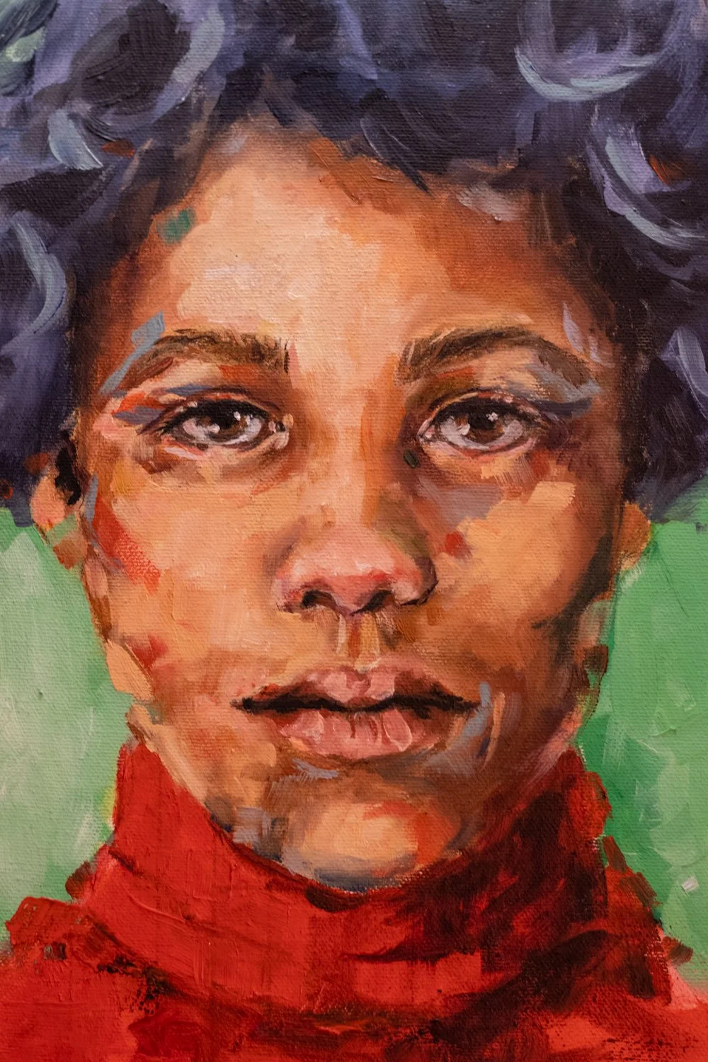 A portrait of a young girl with curly dark hair, gray eyes, and a red shirt against a green background.