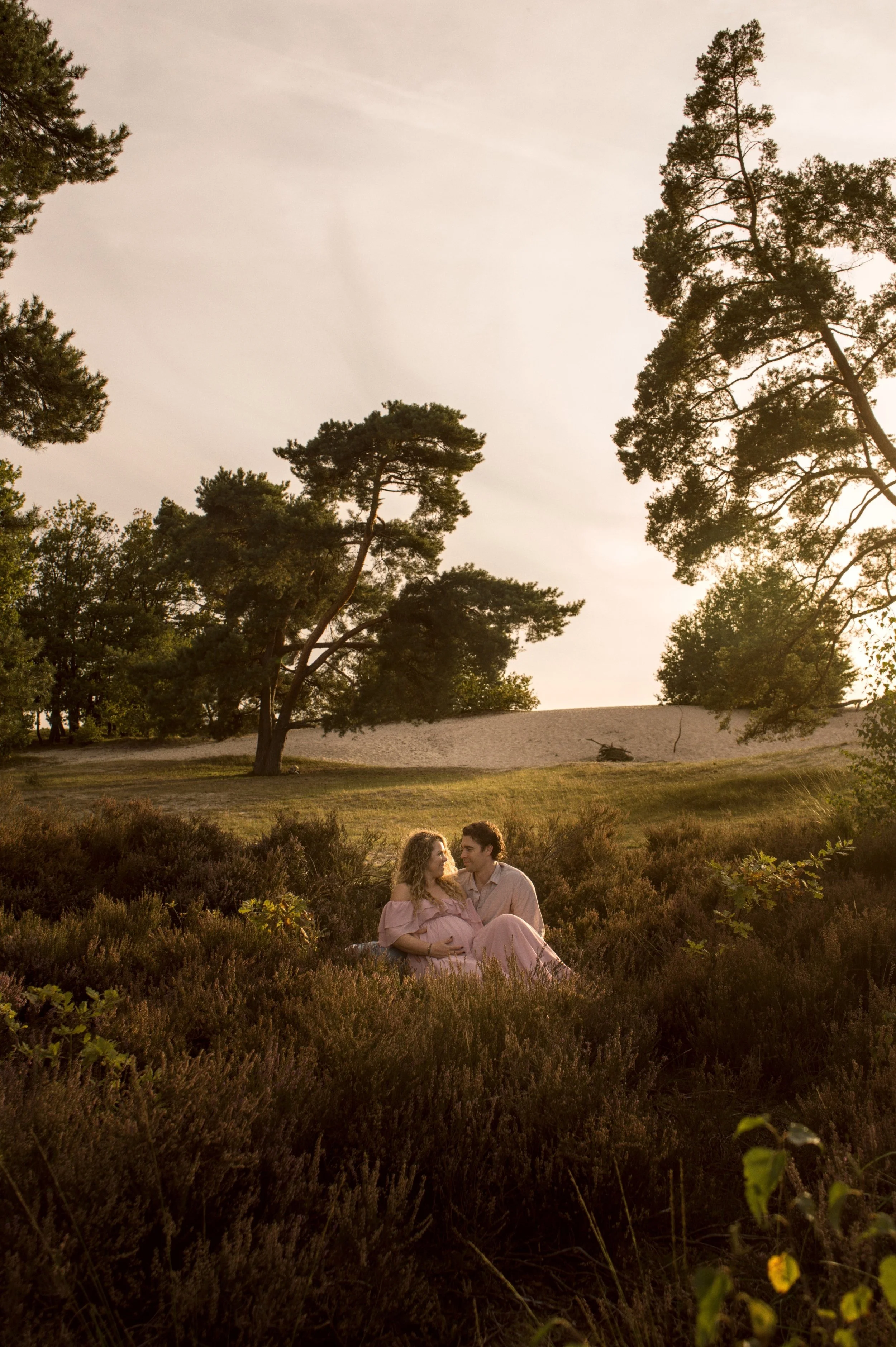 Zwangerschapsshoot: stel samen in de heide in het gouden avondlicht