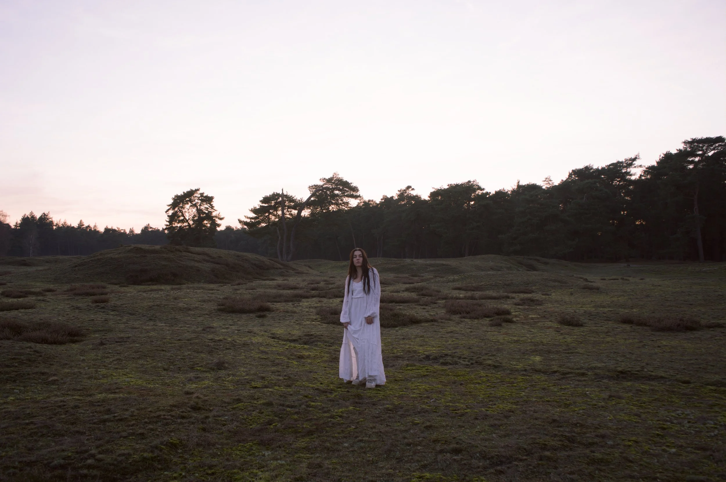Portretfotografie op de heide: vrouw in witte jurk bij zonsondergang