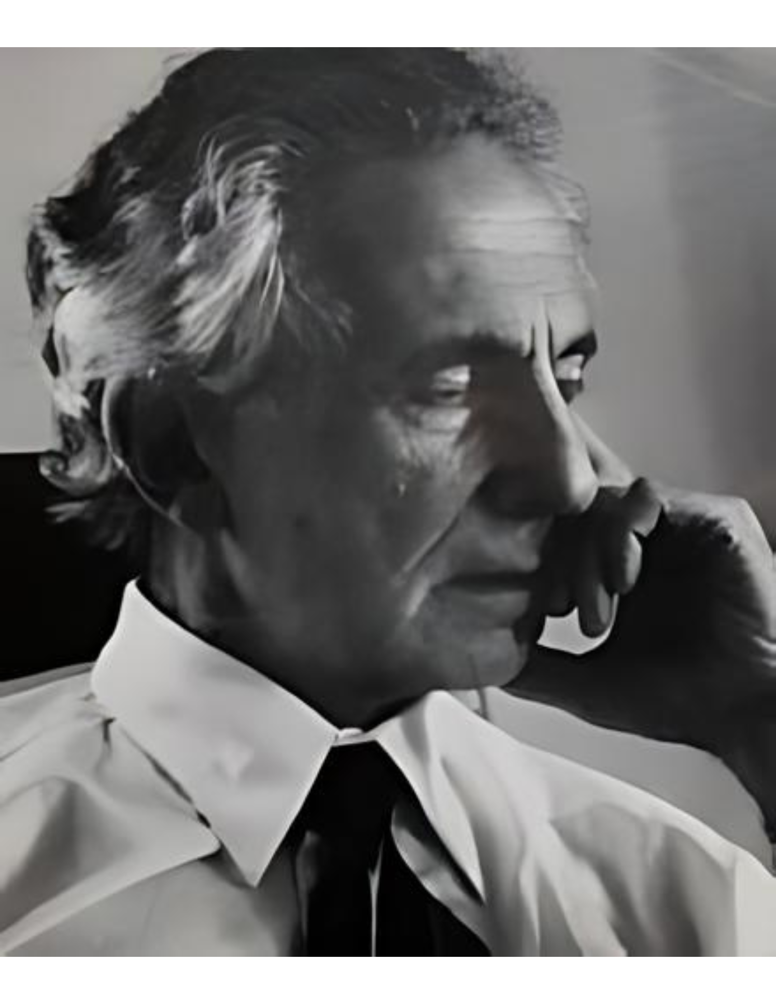 Black and white portrait of an older man in a suit, looking thoughtful.