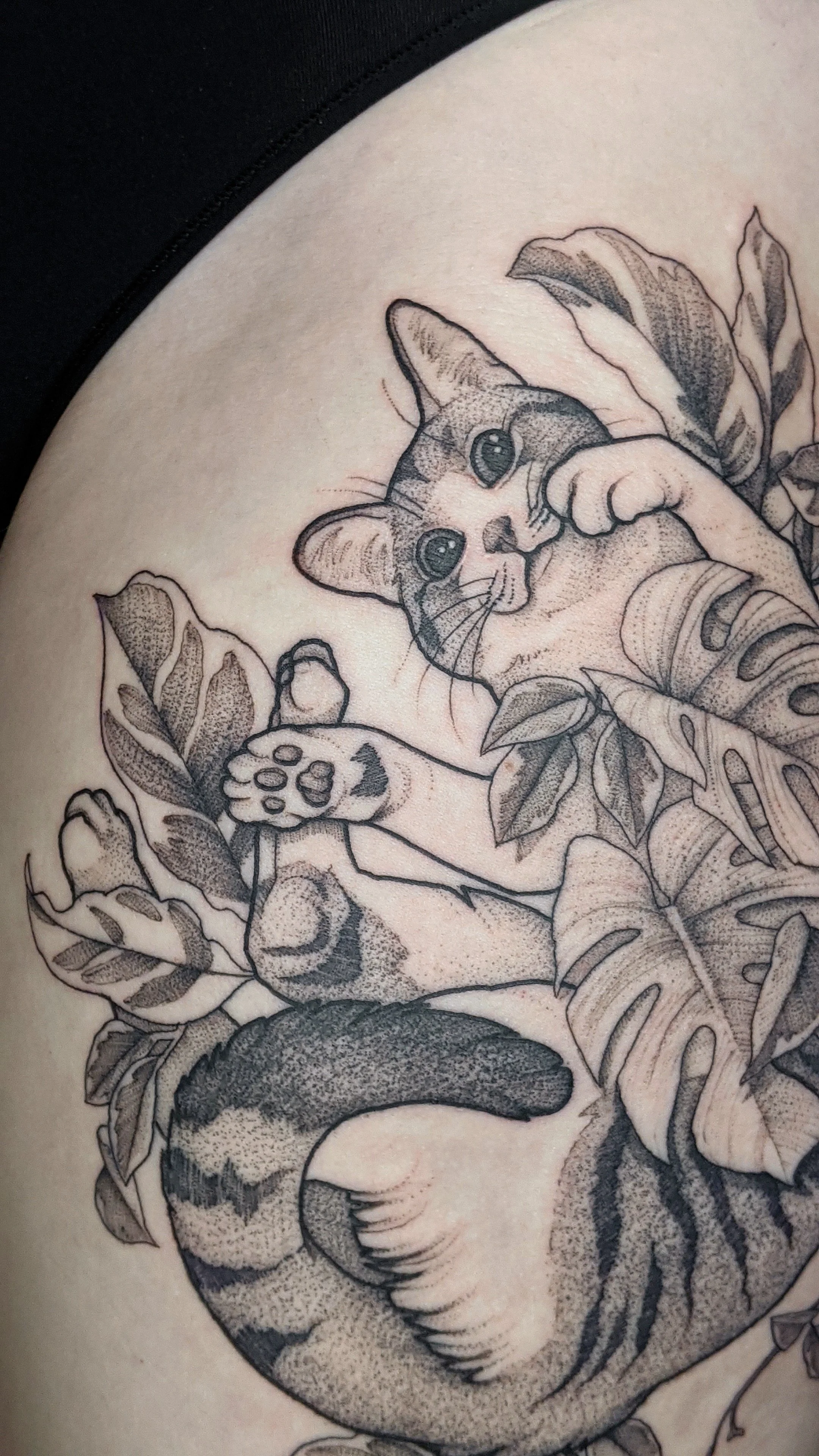 tatouage de chat joueur entouré de feuilles.jpg