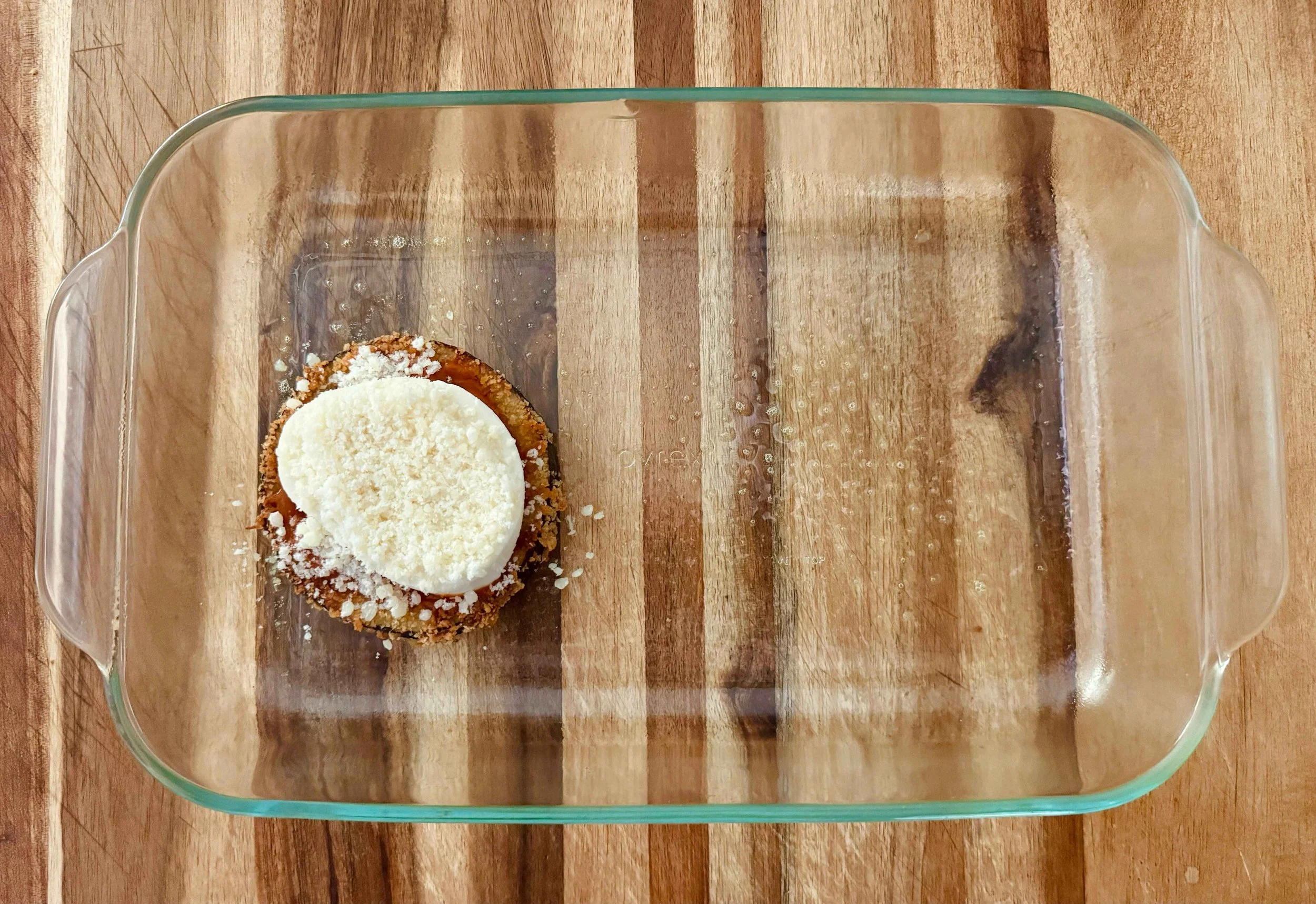 photo of parmesan cheese being added to eggplant stack