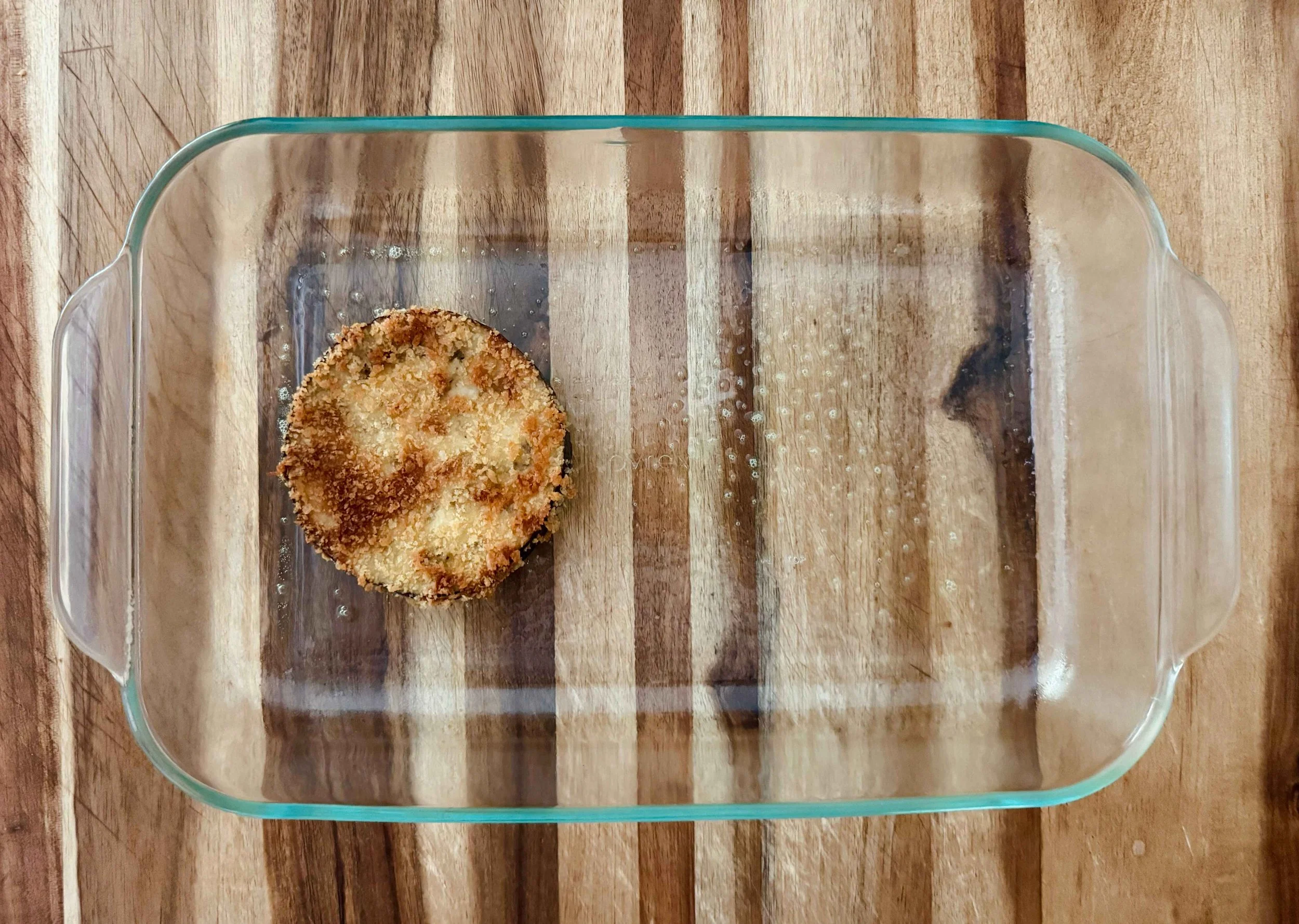 Photo of one eggplant slice placed in a baking dish