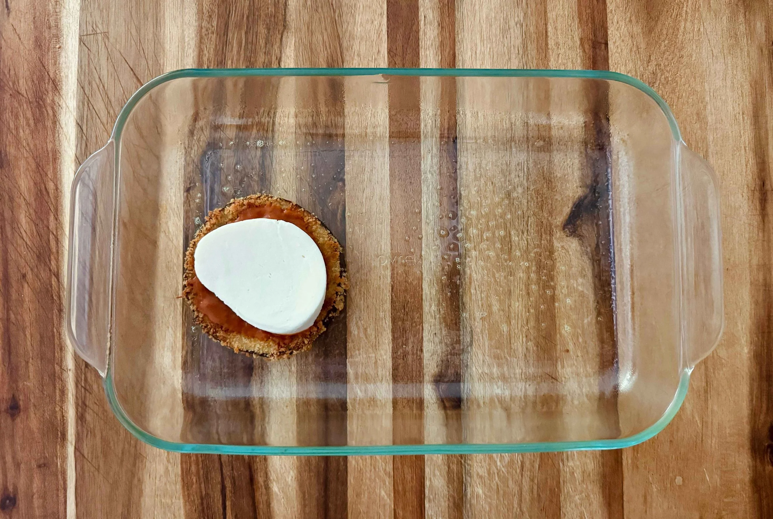 Photo of mozzarella placed on top of eggplant slice topped with marinara sauce