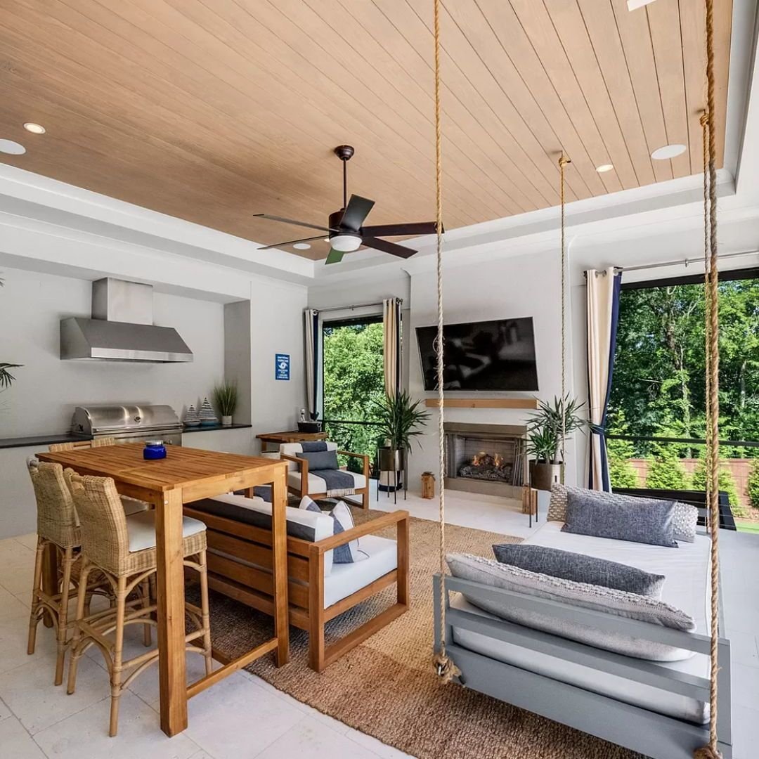 This porch we designed in Myers Park has some of our favorite indoor-outdoor features...motorized screens, 48&quot; outdoor range, outdoor fireplace, surround sound speakers and a hanging bed to take in all the views☀️ Who else is ready for summer?? 